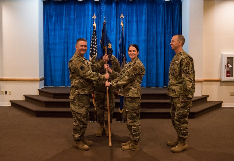 Colonel Robert Ewers, 90th Operations Group commander, passes the guidon to Lt. Col. Amy Grant, 321st Missile Squadron incoming commnader, during the 321st MS change of command ceremony June 28, 2019, on F.E. Warren Air Force Base, Wyo. The ceremony signified the transition of command from Lt. Col. Joel Douglas to Grant. (U.S. Air Force photo by Senior Airman Abbigayle Williams)