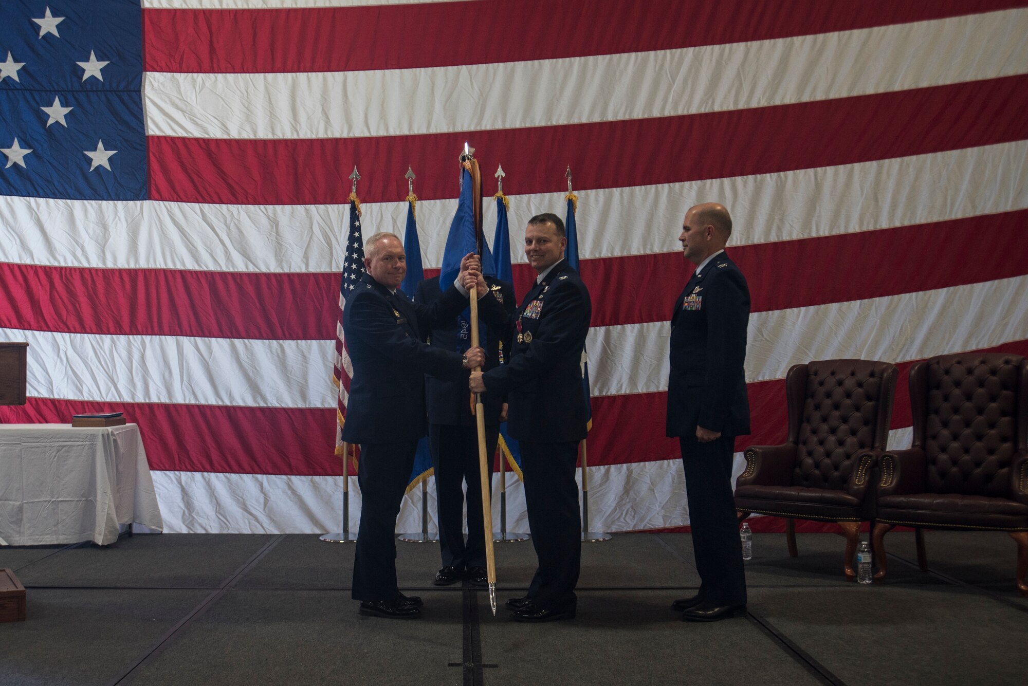 Major Gen. Fred Stoss, 20th Air Force commander, passes the guidon to Col. Joshua Bowman, 582nd Helicopter Group outgoing commander, during the 582nd HG change of command ceremony June 28, 2019, on F.E. Warren Air Force Base, Wyo. The ceremony signified the transition of command from Bowman to Col. Jerry Crigger. (U.S. Air Force photo by Senior Airman Abbigayle Williams)
