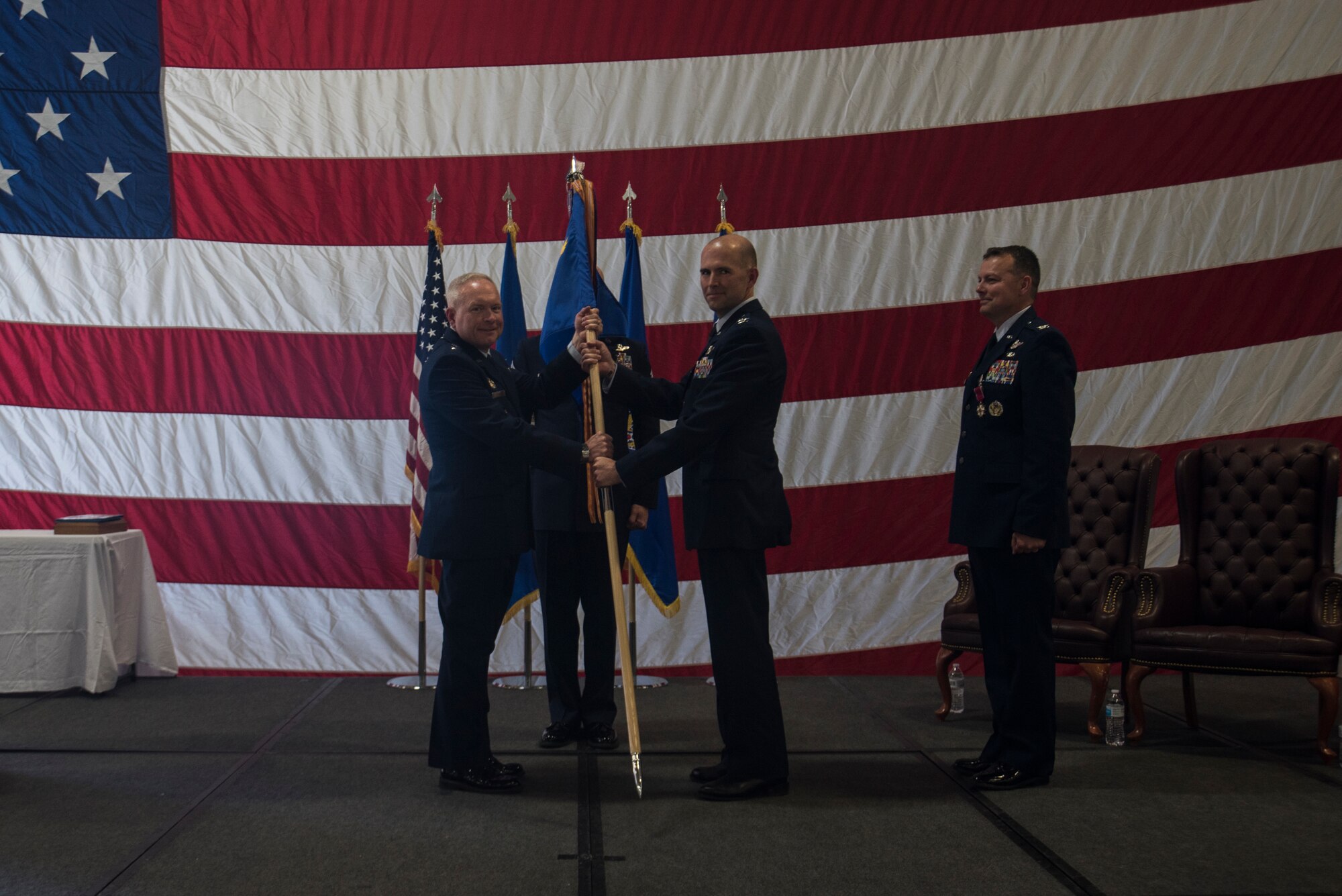 Major Gen. Fred Stoss, 20th Air Force commander, passes the guidon to Col. Jerry Crigger, 582nd Helicopter Group incoming commander, during the 582nd HG change of command ceremony June 28, 2019, on F.E. Warren Air Force Base, Wyo. The ceremony signified the transition of command from Col. Joshua Bowman to Crigger. (U.S. Air Force photo by Senior Airman Abbigayle Williams)