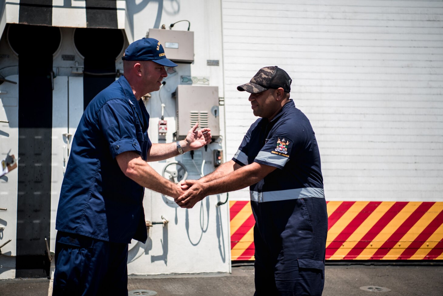 Josaia Maiwai (right), a Fijian fisheries officer, shakes hands with Capt. Bob Little, commanding officer of Coast Guard Cutter Stratton, June 20, 2019, in front of the crew on Stratton’s flight deck while underway in the Western Pacific. Maiwai joined the crew of Stratton in Honolulu to exercise a bilateral ship rider agreement between the United States and Fiji.