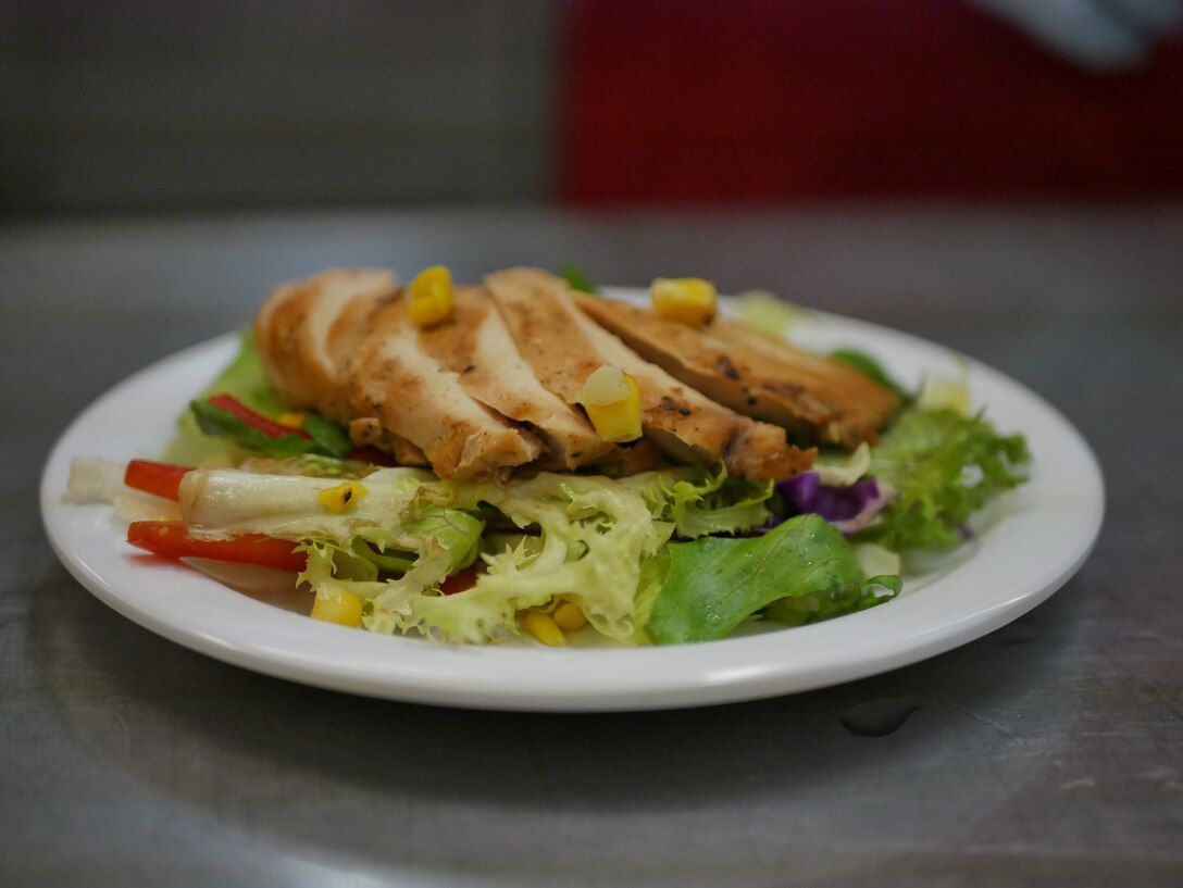 A U.S Marine prepares a salad to be served to the judging panel during the Marine of the 3rd Quarter competition on Camp Courtney, Okinawa, Japan, June 28, 2019. Marines in teams of two represented their units and showcased knowledge,  job proficiency, and military bearing through a rigorous two-day cooking challenge. The competitors were given a secret ingredient, a cherry flavored Pop-Tart, to incorporate into the design of their menus. (U.S. Marine Corps photo by Lance Cpl. Sarah Marshall)