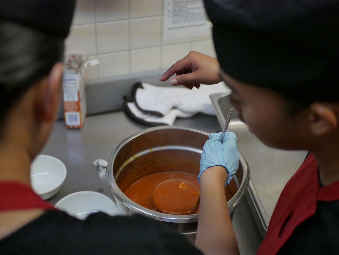 U.S. Marines discuss the layout for plating their dishes during the Marine of the 3rd Quarter competition on Camp Courtney, Okinawa, Japan, June 28, 2019. Marines in teams of two represented their units and showcased their knowledge,  job proficiency, and military bearing through a rigorous two-day cooking challenge. The competitors were given a secret ingredient, a cherry flavored Pop-Tart, to incorporate into the design of their menus. (U.S. Marine Corps photo by Lance Cpl. Sarah Marshall)