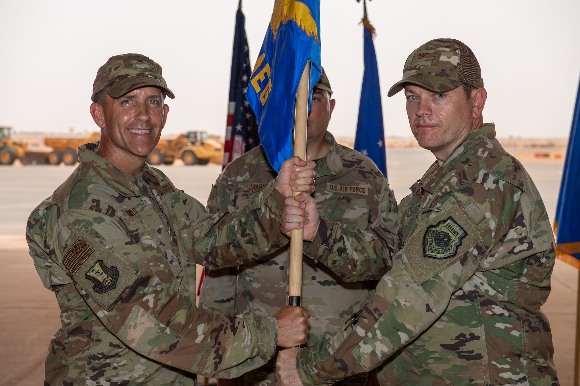 U.S. Air Force Col. Jonathan M. Creer, right, assumes command of the 409th Air Expeditionary Group with Brig. Gen. Michael T. Rawls, 435th Air Ground Operations Wing and 435th Air Expeditionary Wing commander, at Air Base 201, Niger, June 28, 2019. The passing of the guidon is a military tradition signifying the change of authority and responsibility of a unit from one commander to another. (U.S. Air Force photo by Staff Sgt. Devin Boyer)