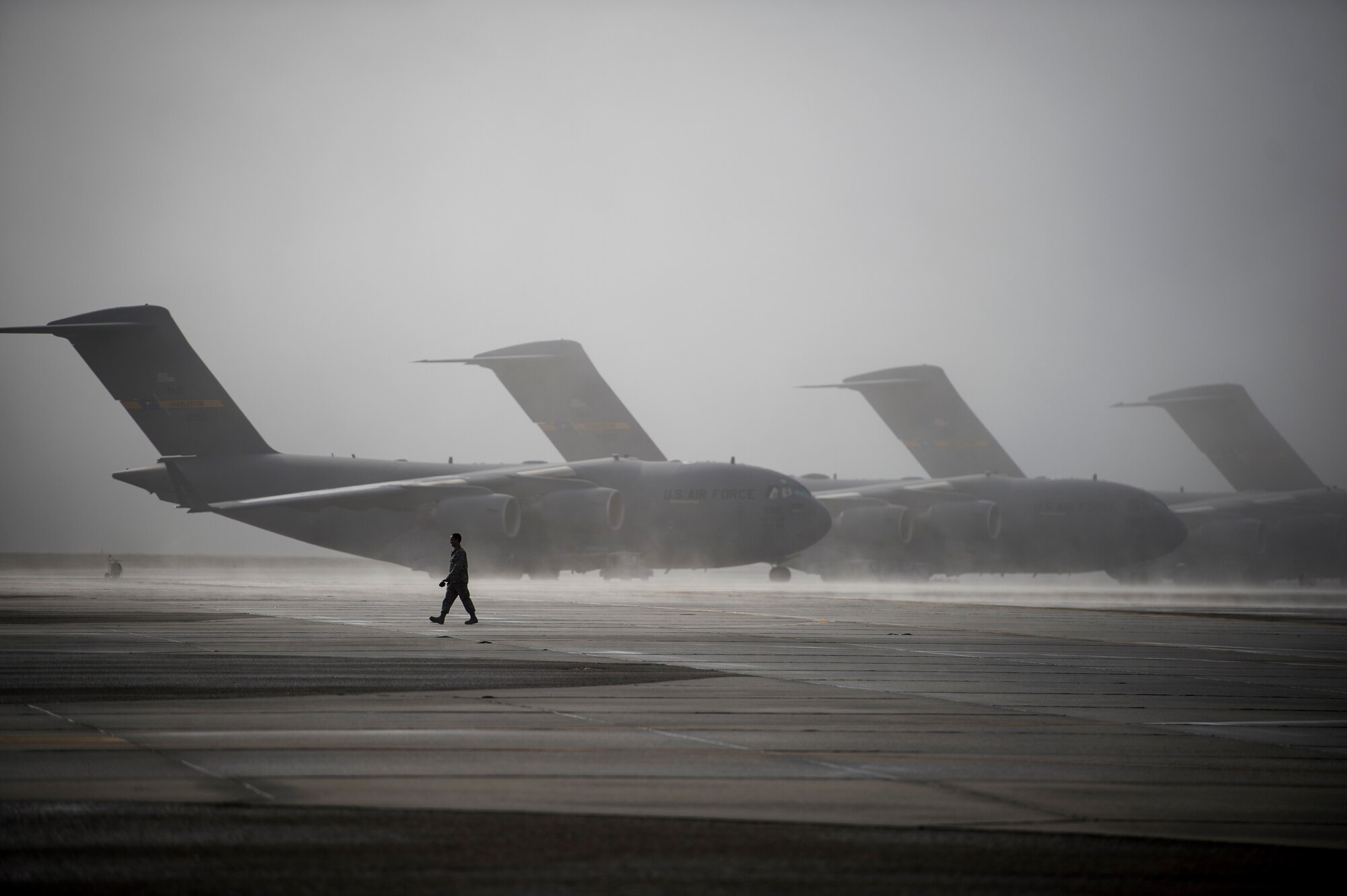An Airmen walks past multiple C-17