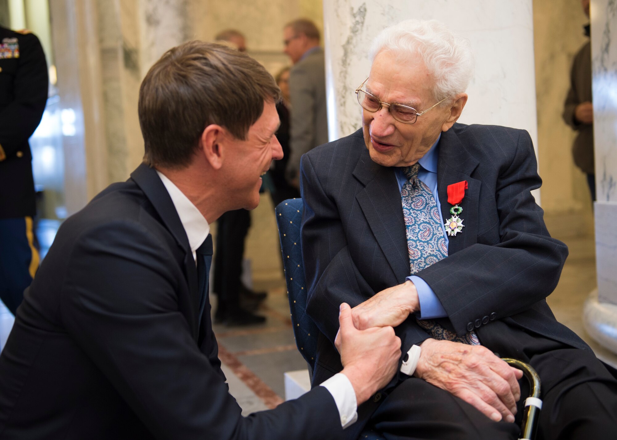 A World War II veteran and Purple Heart recipient, shakes the hand of French Consul