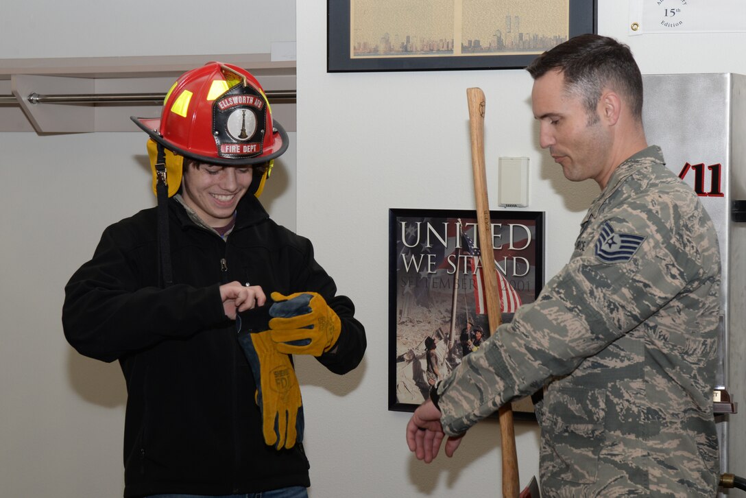 Justin Mohler, a teenager with Make-A-Wish South Dakota, was made an honorary firefighter by the 28th Civil Engineer Squadron Fire and Emergency Services flight during a base tour at Ellsworth Air Force Base, S.D., Feb. 26, 2019. The tour concluded at this portion with Justin being presented a personalized fire axe and helmet to signify his position as an honorary fire fighter. (U.S. Air Force photo by Senior Airman Nicolas Z. Erwin)