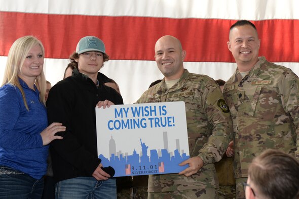 Melanie Barclay, the Make-A-Wish South Dakota regional director; Maj. Jose Crespo, the 28th Logistics Readiness Squadron commander; and Lt. Col. George Nichols, the 28th Mission Support Group deputy commander, notify Justin Mohler (second from the left), a teenager with Make-A-Wish, that his wish to visit the Sept. 11 memorial in New York City has been granted during a special event at Ellsworth Air Force Base, S.D., Feb. 26, 2019. Justin and his family are planning to visit the memorial in June. (U.S. Air Force photo by Senior Airman Nicolas Z. Erwin)