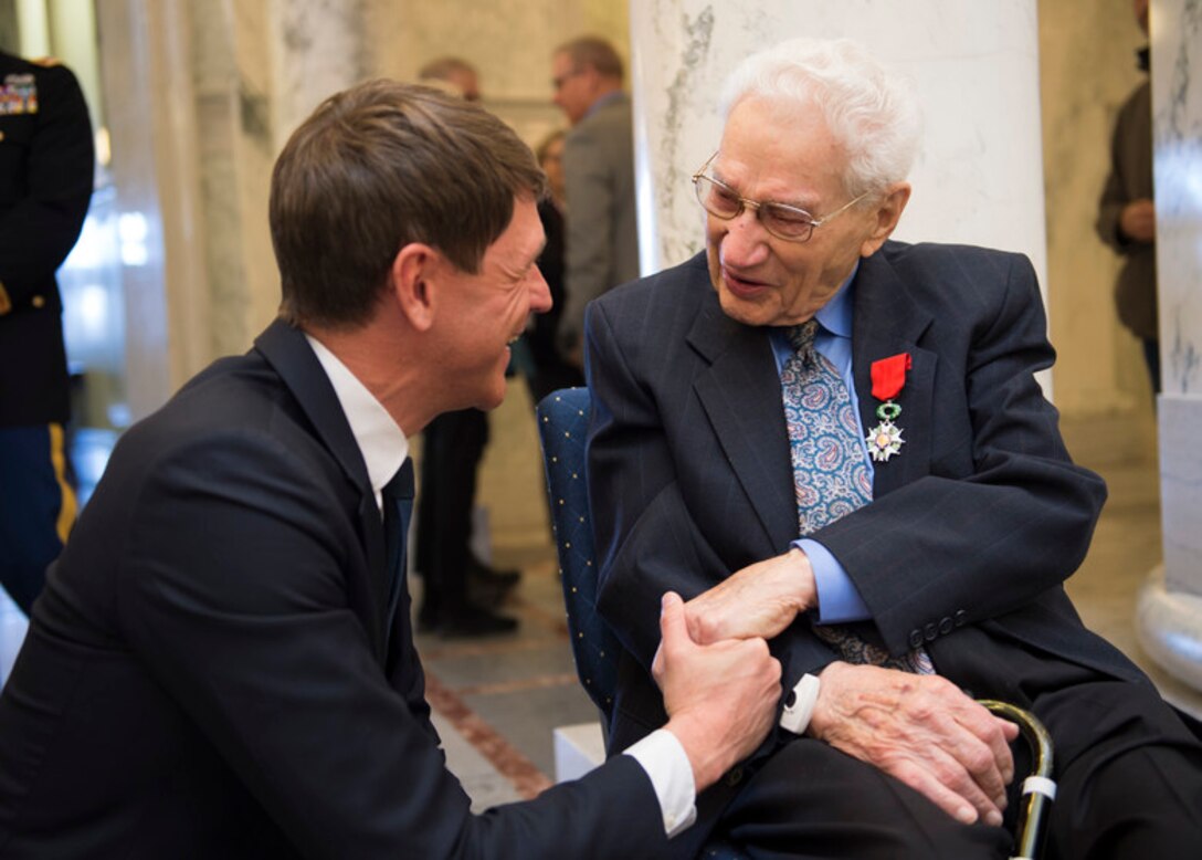 Emil Reich, a 99-year-old World War II veteran and Purple Heart recipient, shakes the hand of French Consul General Lebrun-Damiens at the Idaho State Capitol Building in Boise, Idaho, Feb. 22, 2019. Reich received France’s highest award, the French Legion d’Honneur, for his efforts on the shores of Normandy during D-Day. (U.S. Air National Guard photo by Airman 1st Class Mercedee Wilds)