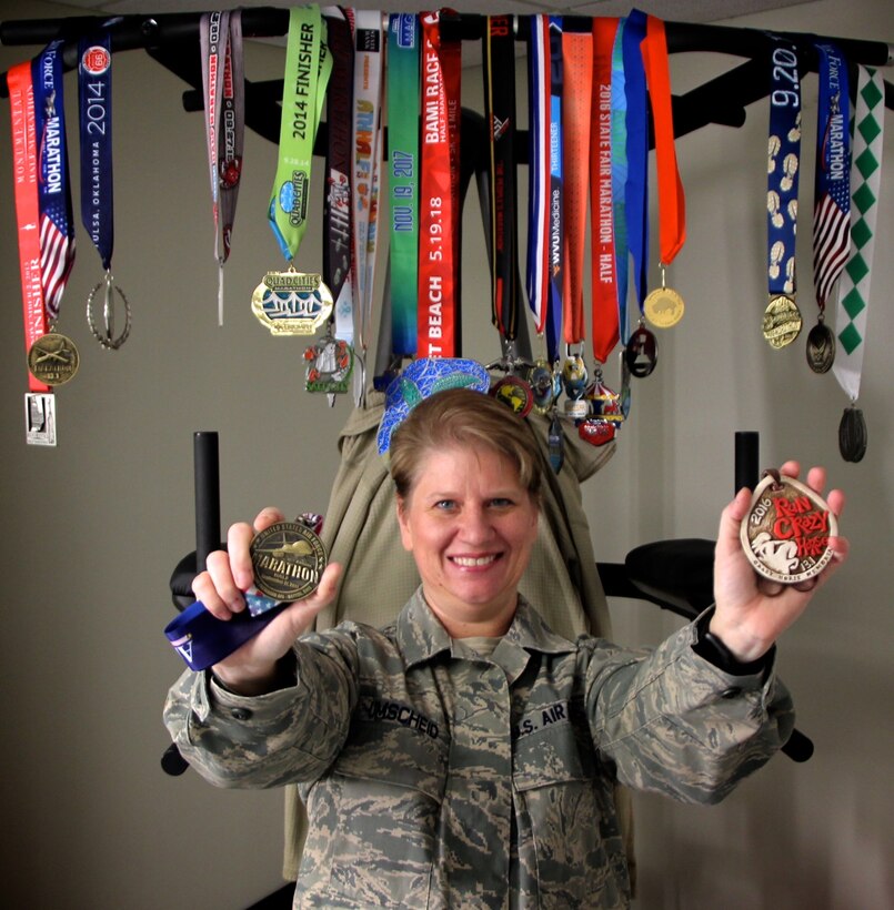 Master Sgt. Cynthia Umscheid, 932nd Medical Group, shows off her two favorite marathon medals.  She was motivated to run more often and for longer distances by a disappointment.  "Several years ago, I failed my Air Force fitness test; I was in school and not eating correctly.  I decided I needed a new goal to keep me going.  I thought about it and I wanted to do a run in every state in America, and sat down and made a long range plan," said Sergeant Umscheid.  

For those just getting started or needing additional help, she has a recommendation:  "Find out what works for you and start this week by getting out and walking a minute, then run a minute.  Stick with your goals, have a plan and keep moving," said Umscheid.   

(U.S. Air Force photo by Lt. Col. Stan Paregien)