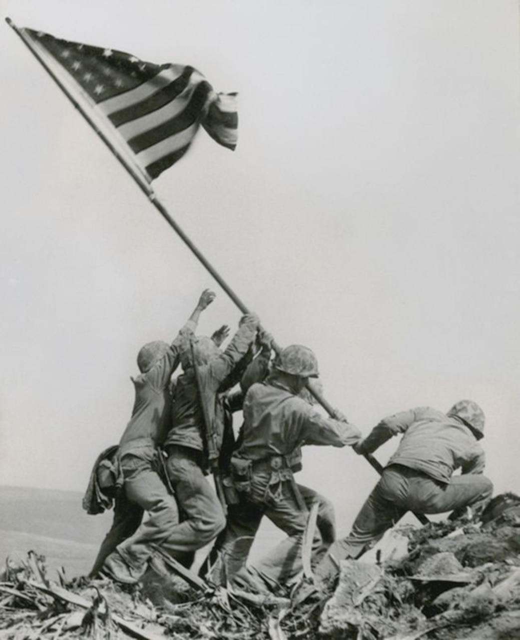 Marines in uniform raise the American flag.