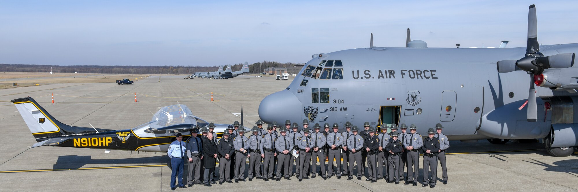 Ohio State Highway Patrol members pose for a photo in front of a 910th Airlift Wing C-130H Hercules aircraft that features nose art of the OSHP’s ‘Flying Wheel’ logo and an OSHP aircraft on the flight line here March 1, 2019.