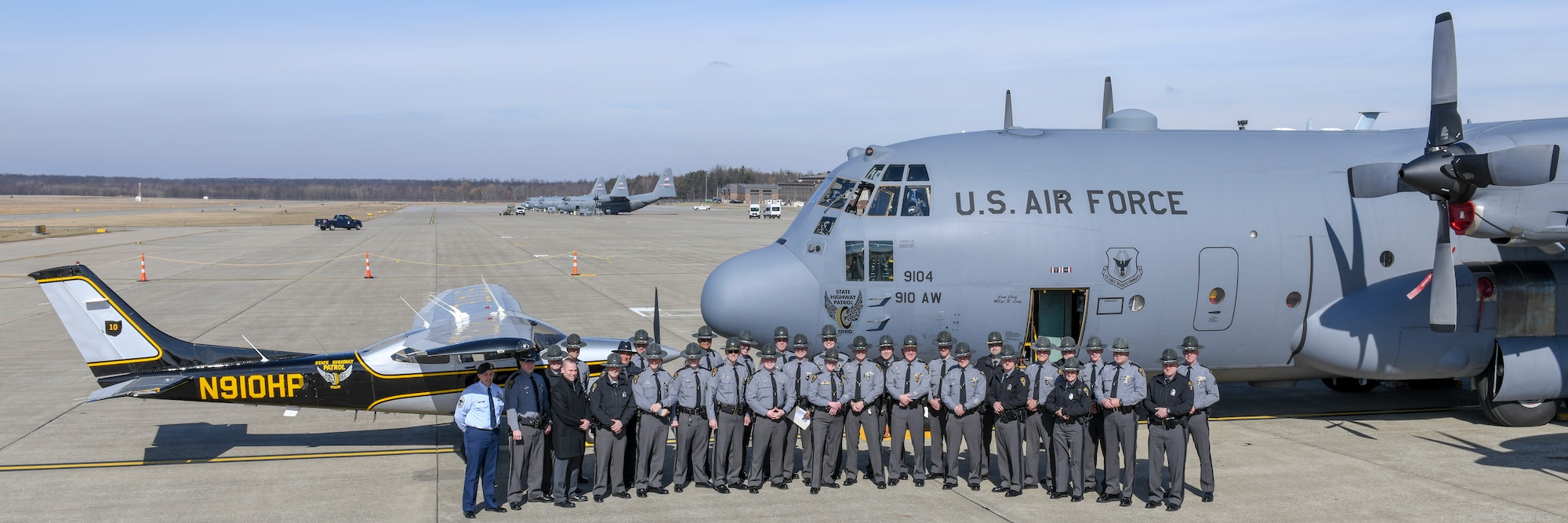 Ohio State Highway Patrol members pose for a photo in front of a 910th Airlift Wing C-130H Hercules aircraft that features nose art of the OSHP’s ‘Flying Wheel’ logo and an OSHP aircraft on the flight line here March 1, 2019.