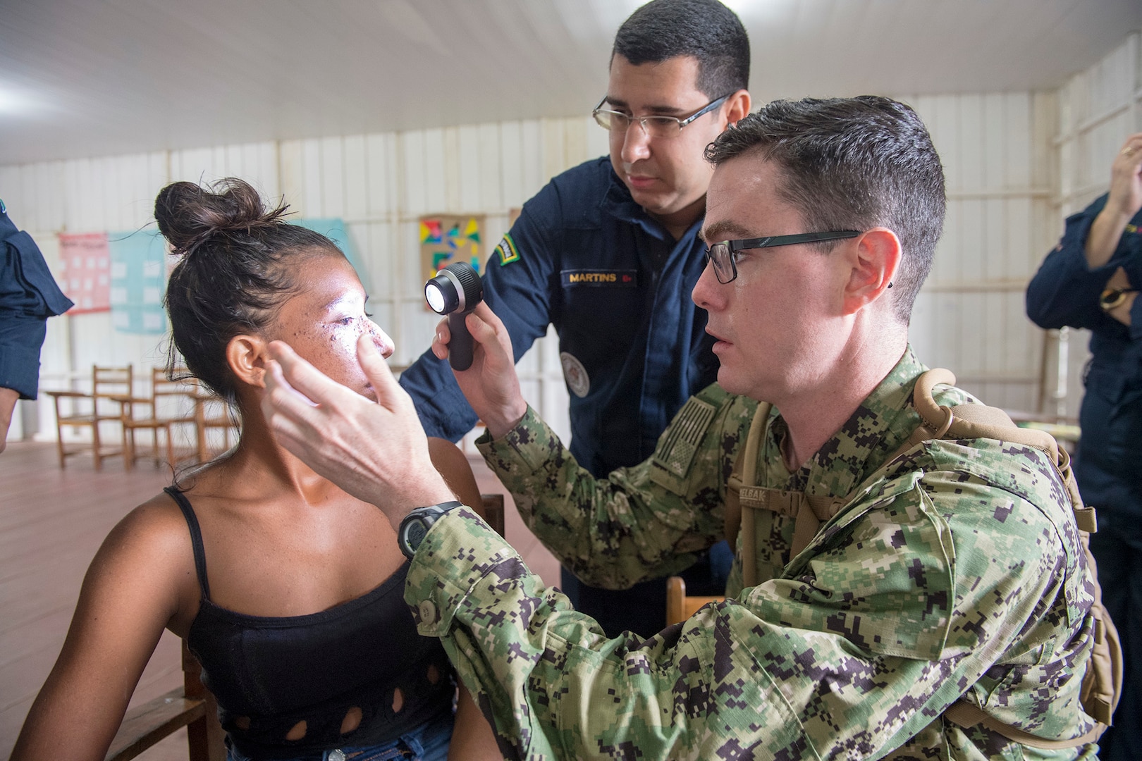 Lt. Cmdr. John Roman and Brazilian navy 1st Lt. Gilvan Martins examine a patient during a medical clinic in Vencedor, Brazil, Feb. 27.