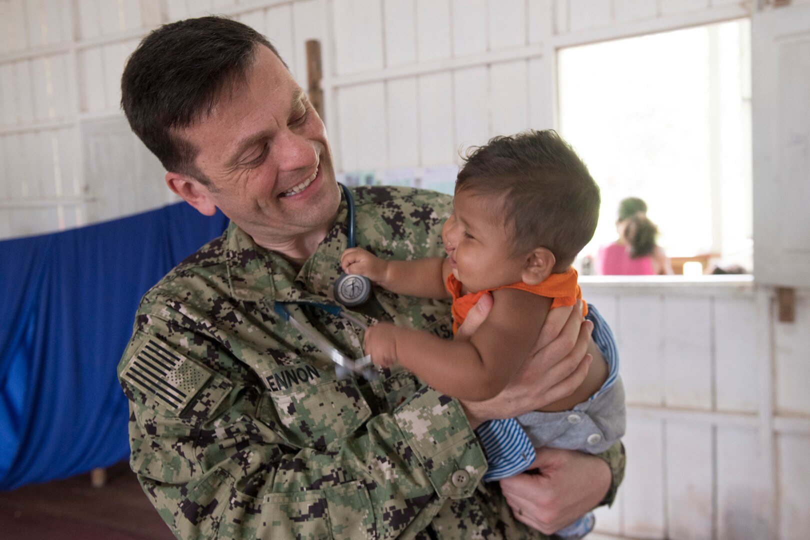 Lt. Cmdr. Robert Lennon meets with a young patient during a medical clinic in Vencedor, Brazil, Feb. 27.