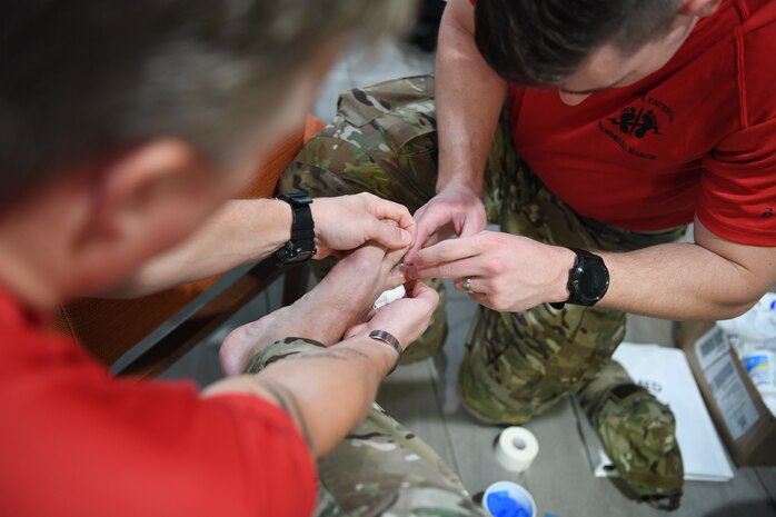 A Special Operations Surgical Team member with the 24th Special Operations Wing bandages a Special Tactics Airman’s foot during the Special Tactics Memorial March, Feb. 27, 2019, in Louisiana. Twenty Special Tactics Airmen ruck from the Medina Annex at Joint Base San Antonio-Lackland, Texas, to Hurlburt Field, Fla., to pay tribute to Staff Sgt. Dylan J. Elchin, who was killed in Afghanistan, Nov. 27, 2018, and 19 other Special Tactics Airmen who have been killed in action since 9/11. The ruck march takes Special Tactics members across five states and 830 miles. (U.S. Air Force photo by Senior Airman Ridge Shan)