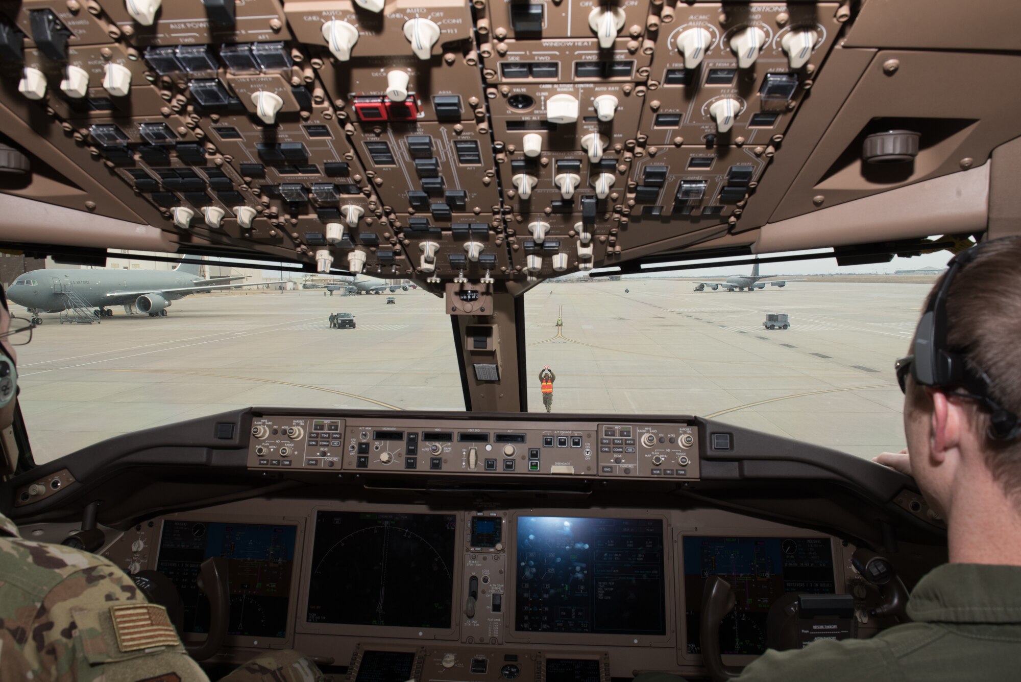 Staff. Sgt. Angel Guzman, 22nd Aircraft Maintenance Squadron crew chief, marshals a KC-46A Pegasus to a stop at McConnell Air Force Base, Kan., Feb. 28, 2019. There were two KC-46A Pegasus flights during the week as part of the familiarization period for the new aircraft the Air Force accepted Jan. 25, 2019. (U.S. Air Force photo by Staff. Sgt. David Bernal Del Agua)