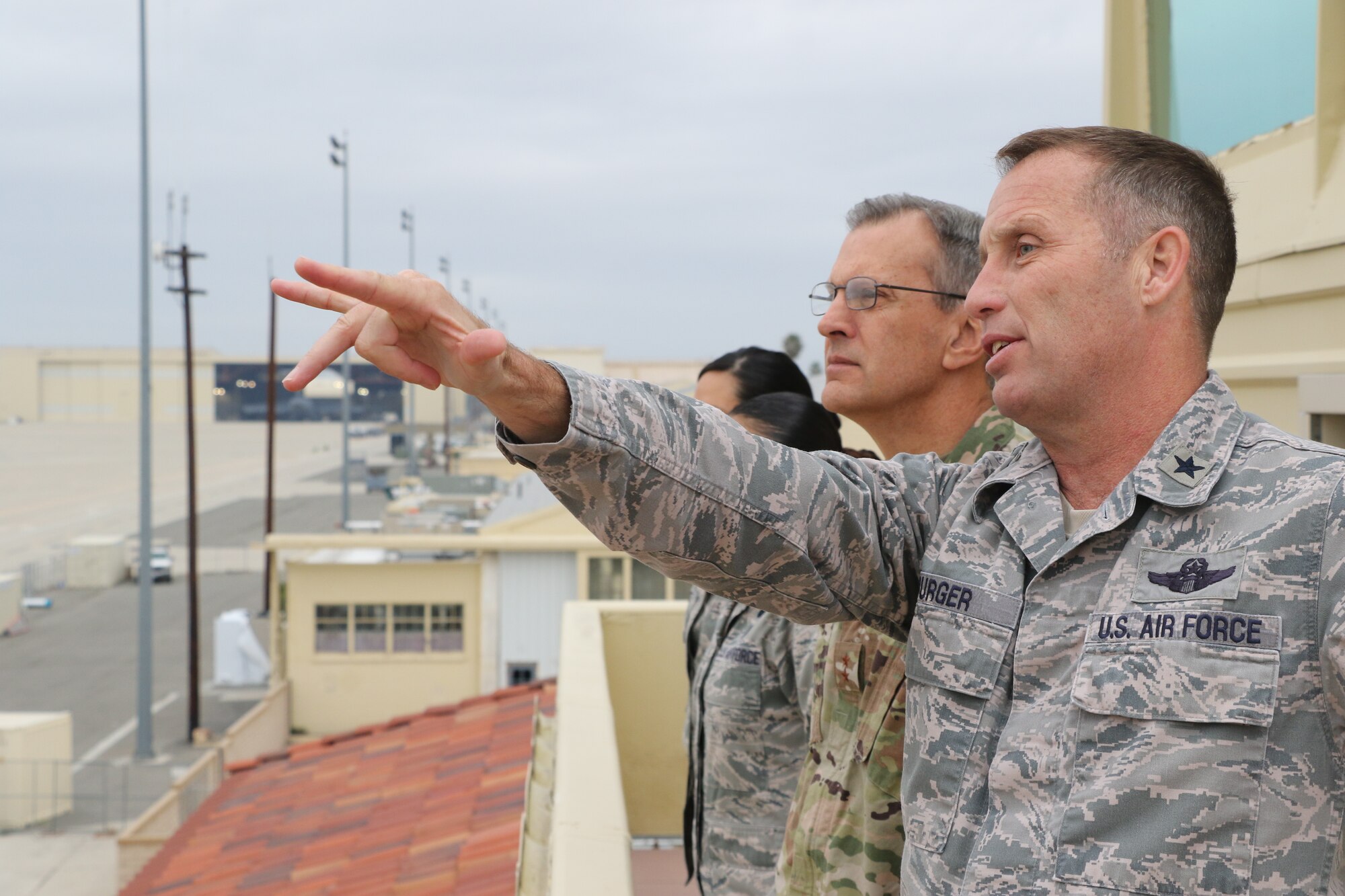 U.S. Air Force Brig. Gen. Matthew Burger, commander, 452nd Air Mobility Wing, March Air Reserve Base, points toward multiple C-17 Globemaster III aircraft on the flight line here as U.S. Air Force Maj. Gen. Randall Ogden, commander, Fourth Air Force, March ARB observes Feb. 9, 2019