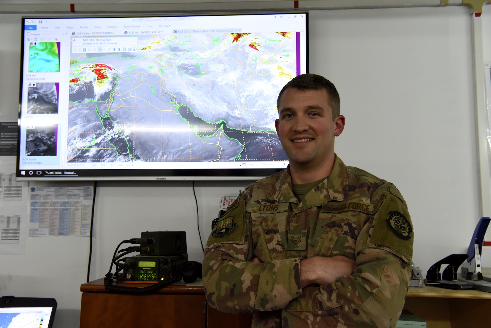 Tech. Sgt. Kyle Lyons, 380th Expeditionary Operational Support Squadron NCOIC of weather operations, pose for a photo in front of meteorological satellite at Al Dhafra Air Base, United Arab Emirates, Feb. 26, 2019.