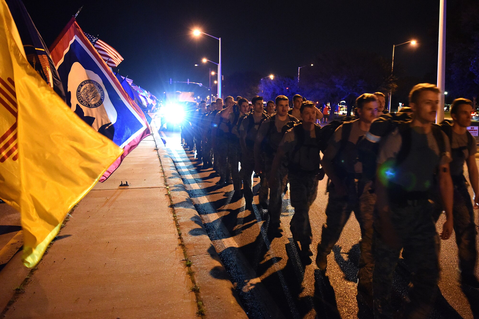 Airmen from the 81st Training Group hold the 50 flags while the 352nd Battlefield Airmen Training Squadron Detachment 1, join a team of Special Tactics Airmen ruck marching through Biloxi, Mississippi March 1, 2019. Twenty Special Tactics Airmen ruck from Medina Annex at Lackland Air Force Base, Texas, to Hurlburt Field, Florida, to pay tribute to Staff Sgt. Dylan J. Elchin, who was killed in Afghanistan on Nov. 27, 2018, and 19 other Special Tactics Airmen who have been killed in action since 9/11. The ruck march takes ST members across five states and 830 miles. (U.S. Air Force photo by Senior Airman Suzie Plotnikov)