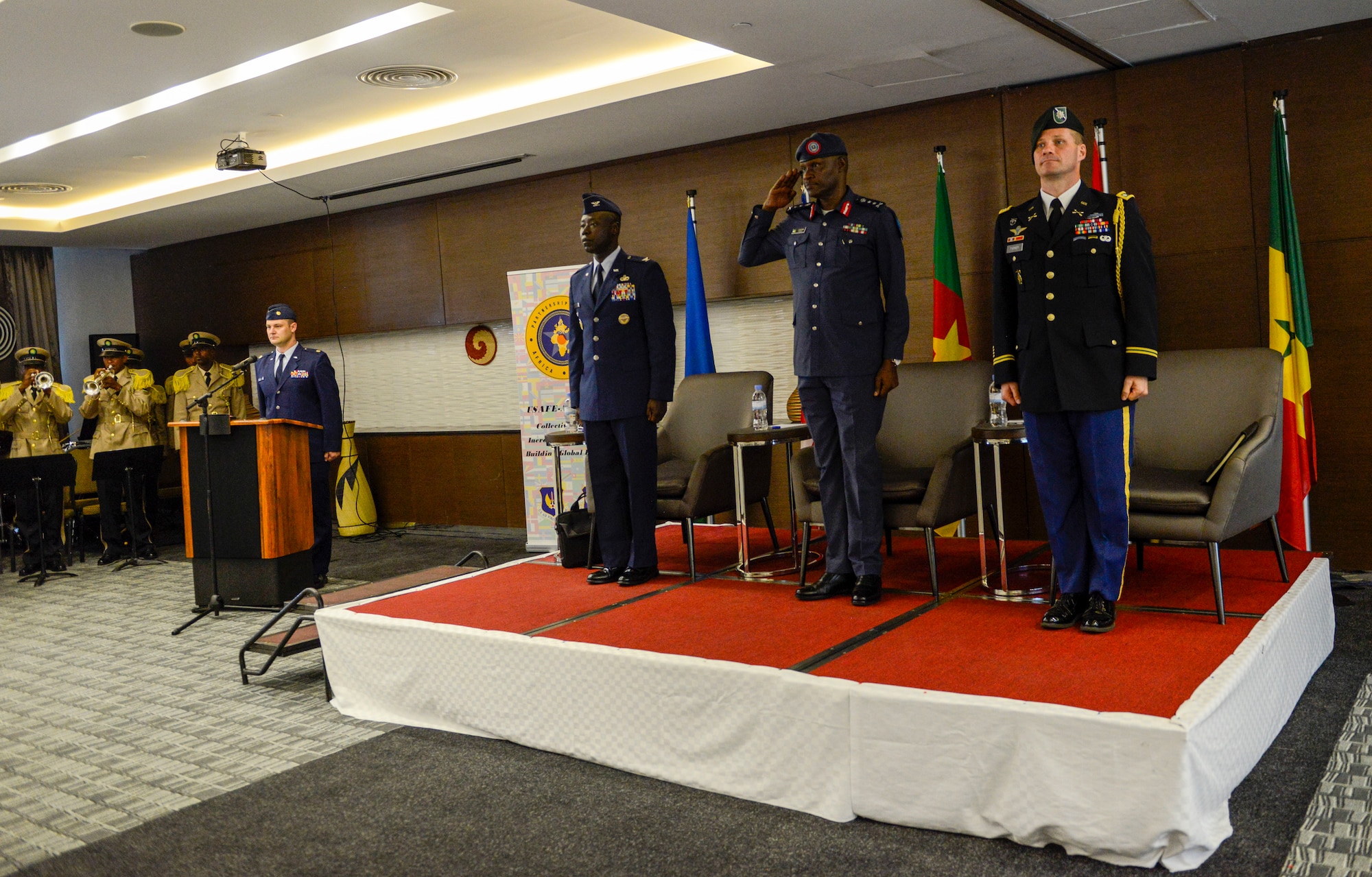Rwanda Air Force Air Chief Maj. Gen. Charles Karamba, center, is joined on stage by representatives from U.S. Air Forces in Europe-Air Forces Africa and the U.S. Embassy in Kigali during the African Partnership Flight Rwanda opening ceremony in Kigali, Rwanda, March 4, 2019. The APF program is intended to build strong, transparent partnerships that enhance regional stability and security. APF Rwanda's focus is on sharing best practices for flight, ground, and weapon safety. (U.S. Air Force photo by Tech. Sgt. Timothy Moore)