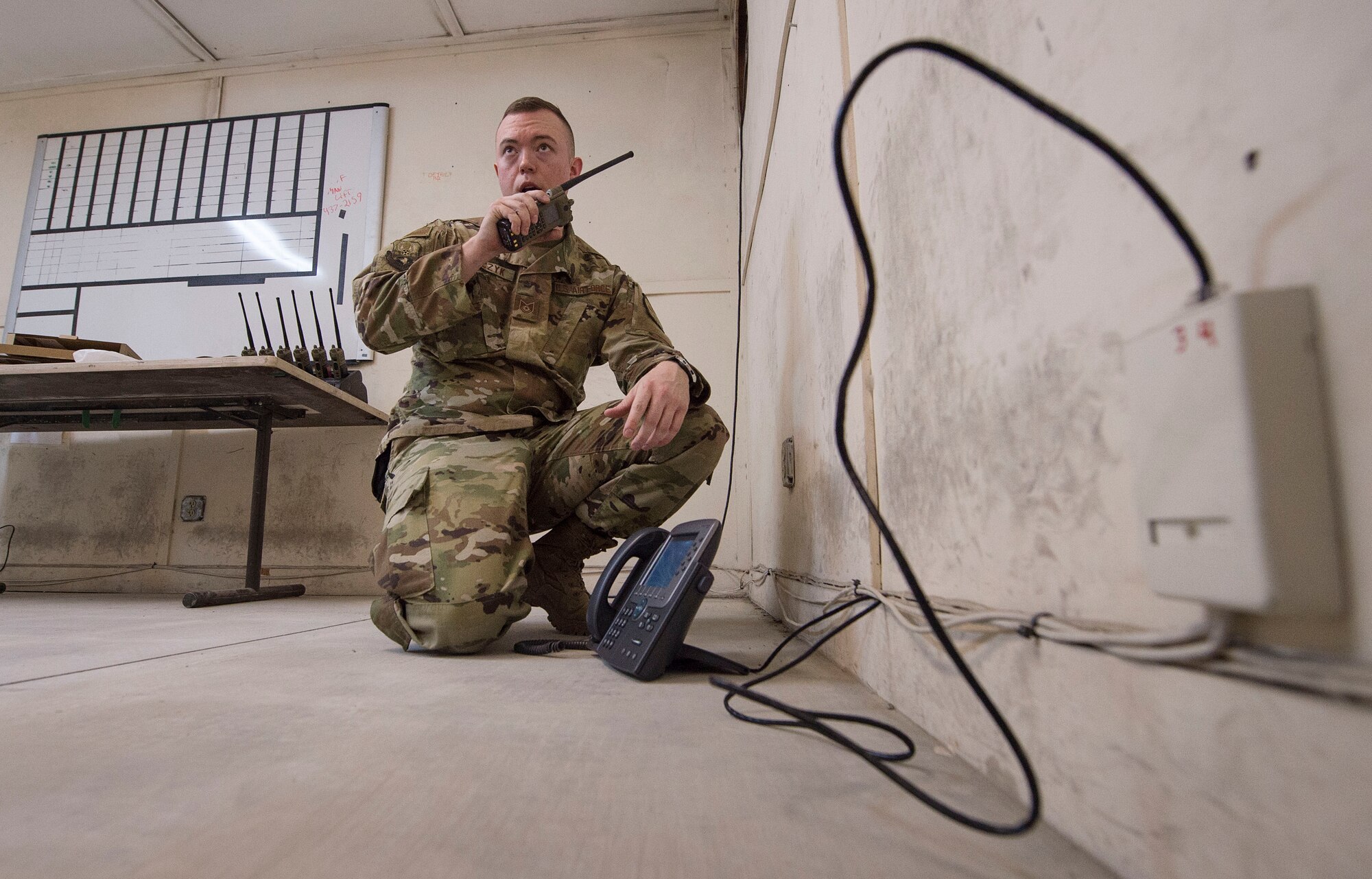 Tech. Sgt. Wesley Sobczyk, 379th Expeditionary Communications Squadron (ECS) cyber transport technician, uses a radio to talk with a coworker while setting up communications infrastructure for a coalition partner facility Feb. 8, 2019, at Al Udeid Air Base, Qatar. Sobczyk is part of a “beddown” team that enables power projection by establishing communications capabilities such as networks, Voice over Internet Protocol telephones, and radios from the ground up (U.S. Air Force photo by Tech. Sgt. Christopher Hubenthal)
