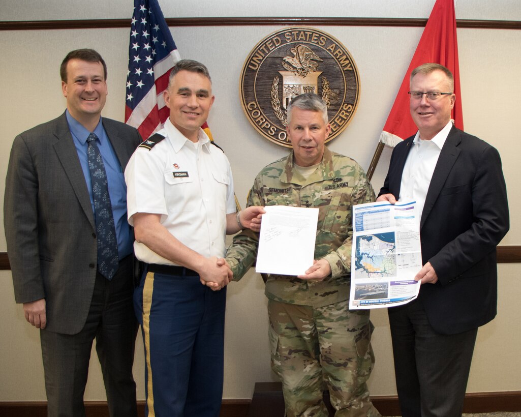 Greg Steele, left, Norfolk District Water Resources Division chief, along with Mike Darrow, right, Norfolk District deputy district engineer for project management, and Col. Patrick Kinsman, Norfolk District commander, hold up the signed Chief's Report for the Norfolk Coastal Storm Risk Management with Lt. Gen. Todd T. Semonite, USACE commanding general.