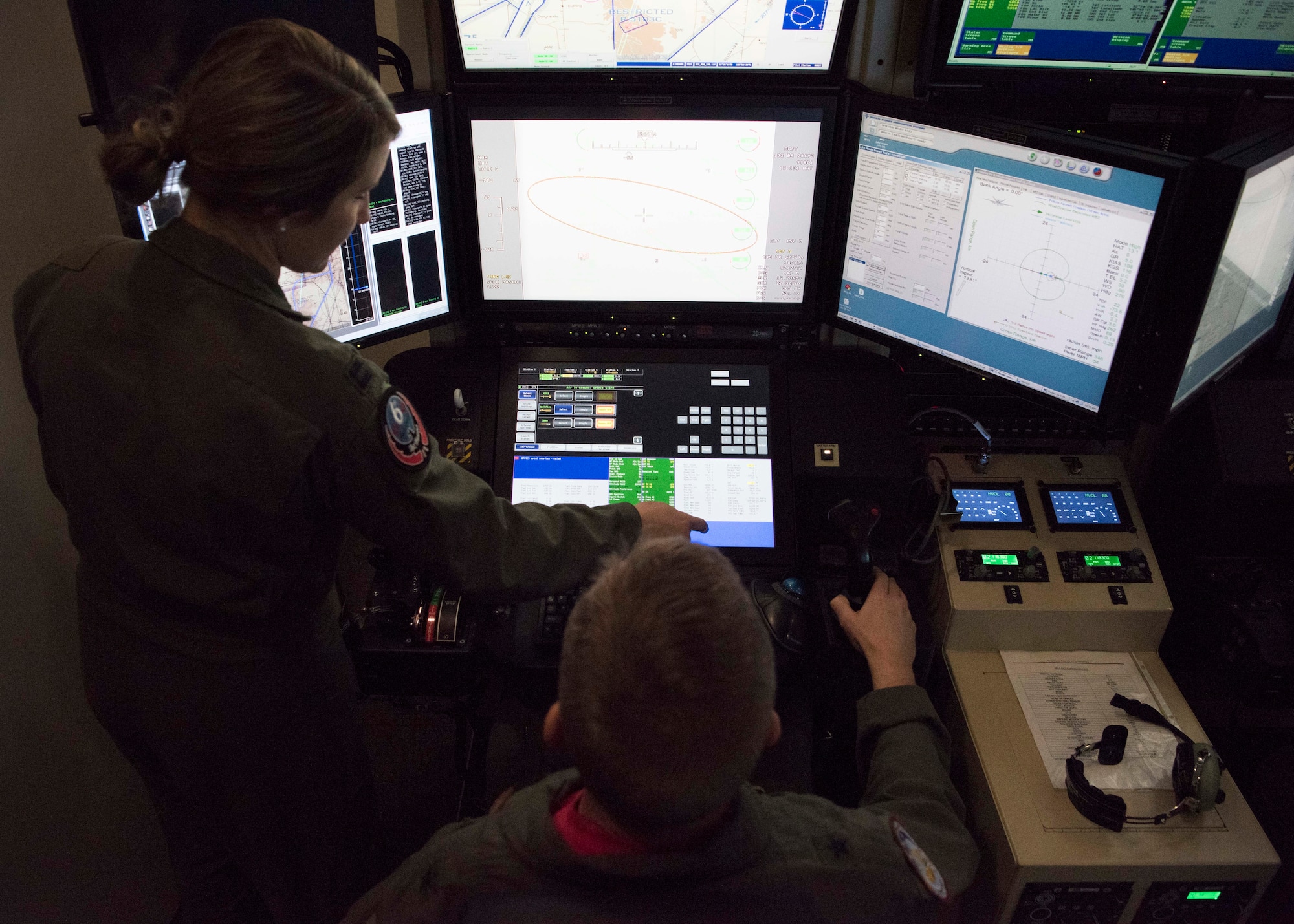 Capt. Amanda Collazzo, 6th Attack Squadron chief of weapons, briefs Brig. Gen. James Cluff, Remotely Piloted Aircraft, Big Wing Intelligence, Surveillance and Reconnaissance director, while he operates a Block 50 MQ-9 Reaper cockpit simulator. The 16th Training Squadron recently upgraded their simulators from the Block 30 model to the Block 50, to keep their training platforms up to date. (U.S. Air Force photo by Staff Sgt. BreeAnn Sachs)