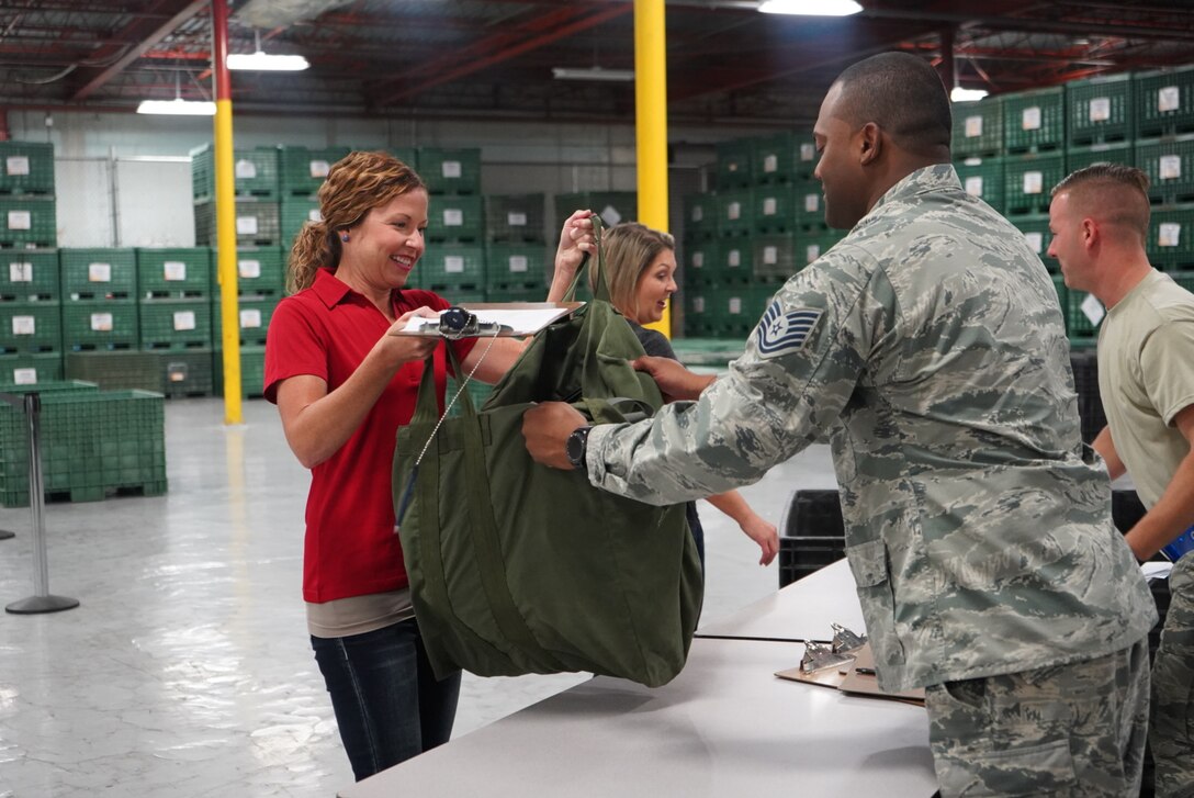 Spouses are given mobility bags to simulate what a deployment line at MacDill Air Force Base, Fla., on March 2, 2019. The Spouses were given the bags before they took flight to get a firsthand look at the mission. (U.S. Air Force photo by Senior Airman Alexis Suarez)