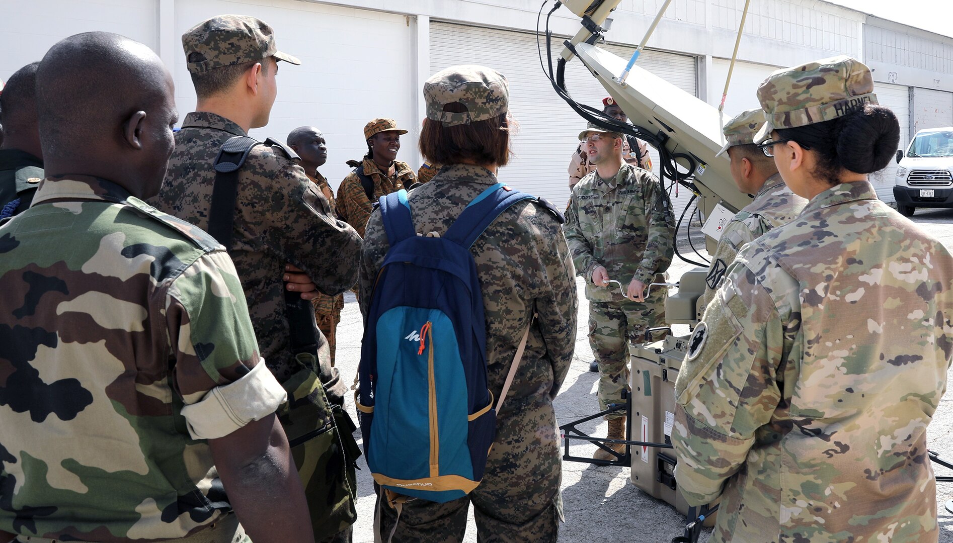 Eighteen signal officers and senior non-commissioned officers from the U.S. Africa Command area of responsibility gather around Staff Sgt. Craig Curtis, 56th Signal Battalion communications, to learn how different components of the satellite system move at Joint Base San Antonio-Fort Sam Houston Feb. 25.