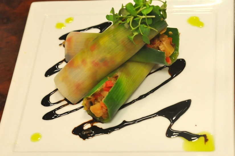 Ratatouille -stuffed leeks are displayed on a white plate.