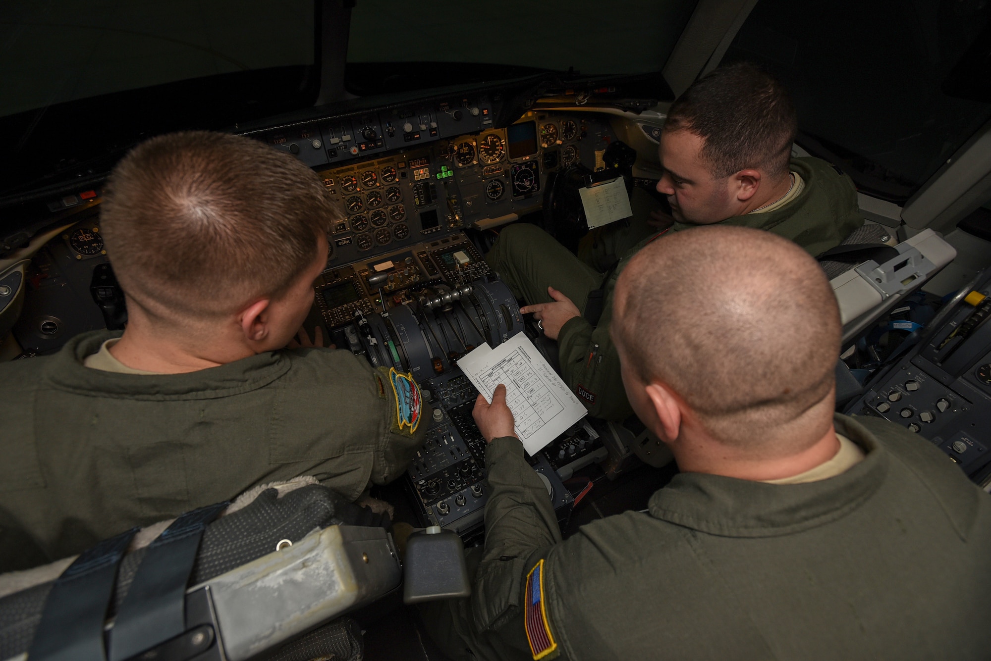 U.S. Air Force 2nd Lt. Kyle Mallard, 78th Air Refueling Squadron KC-10 Extender pilot trainee, Tech. Sgt. Jon Lynes, 32nd Air Refueling Squadron KC-10 flight engineer, and U.S. Air Force Capt. Zachary White, 2nd Air Refueling Squadron KC-10 pilot, read checklists during their initial qualification on a simulator on Joint Base McGuire-Dix-Lakehurst, New Jersey, Dec. 19, 2018. Students must pass their initial qualification tests in the simulator before they operate in a KC-10. (U.S. Air Force photo by Airman 1st Class Ariel Owings)
