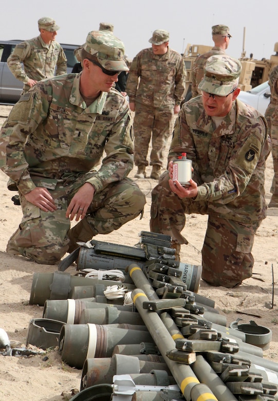 Brigadier Gen. Charles Kemper, deputy commanding general for support, 34th Red Bull Infantry Division, Task Force Spartan, speaks with 1st Lt. Daniel Dixon, 705th Explosive Ordnance Disposal Company, about the ordnance included in this shot pit prior to a controlled detonation of more than 6,800 pounds of unserviceable ammunition on the Udairi Range, Kuwait, Feb. 27, 2019. Kemper assisted in priming the charges for the four separate shot pits.