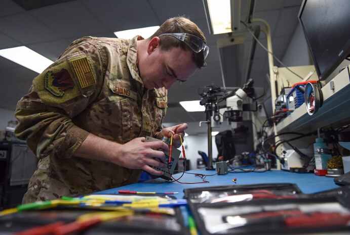 An Airman repairs a broken circuit board.