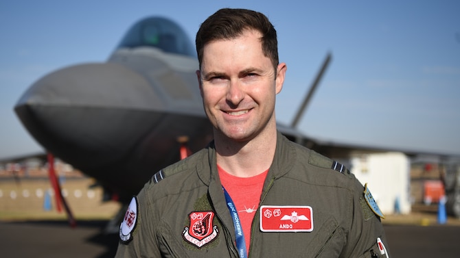 Royal Australian Air Force Flight Lt. Paul Anderton, an F-22 Raptor pilot with the 90th Fighter Squadron, Joint Base Elmendorf-Richardson, Alaska, stands in front of a Raptor at Geelong, Victoria, Australia, Feb. 28, 2019.