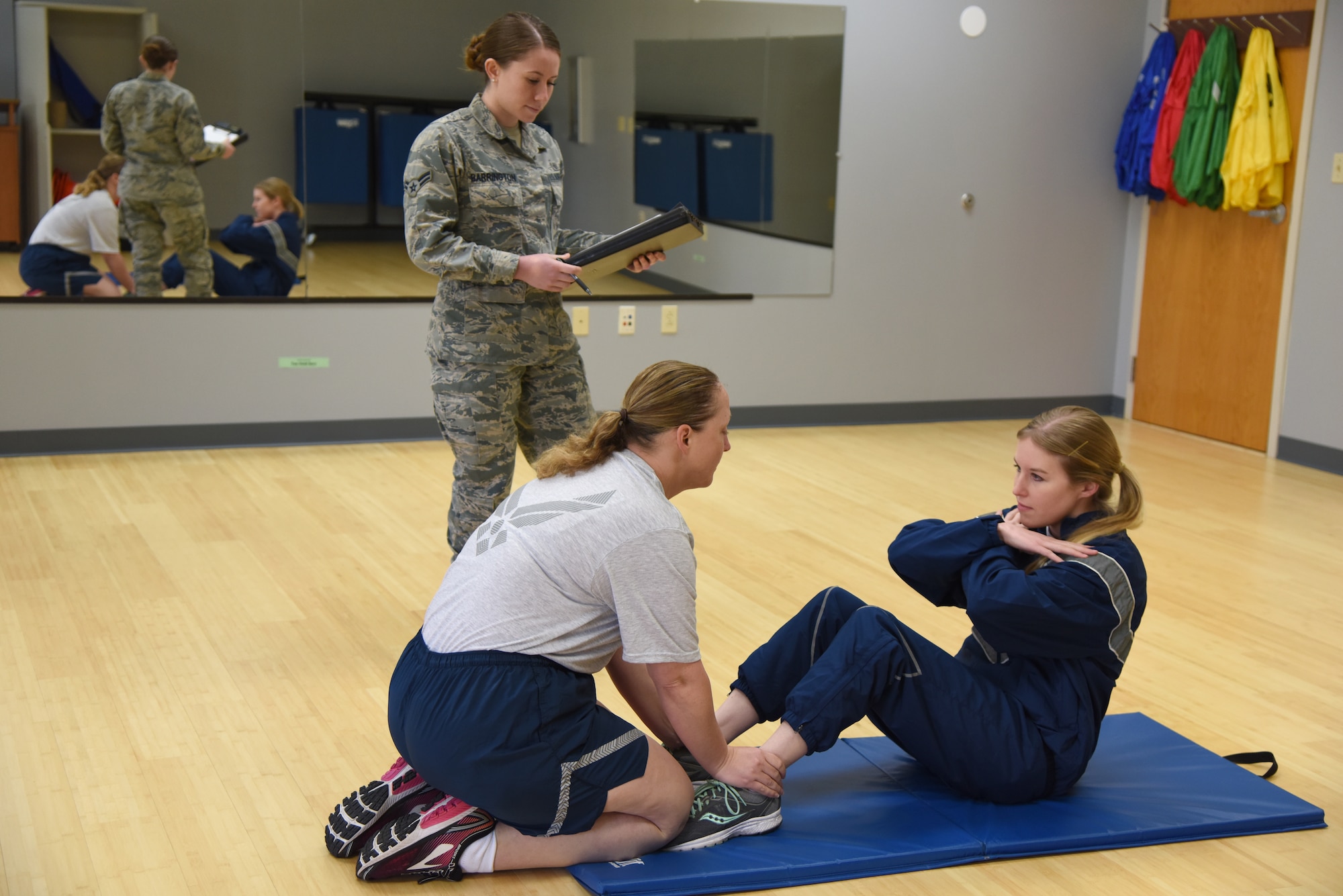 U.S. Air Force Airman 1st Class Alexus Barrington, 81st Inpatient Operation Squadron aerospace medical technician and physical training leader, counts the number of push-ups that Senior Airman Rebecca Fentress, 81st Security Forces Squadron investigator, completes as Senior Master Sgt. Rebecca Janssen, 85th Engineering Installation Squadron operations flight chief, holds her feet inside the new fitness assessment cell building at Keesler Air Force Base, Mississippi, March 4, 2019. The FAC moved to a new location, building 4104, near the Dragon Fitness Center, to better suit Keesler's fitness needs by enhancing the options for members when choosing where they're most comfortable accomplishing the aerobic component of the test. Airmen are now able to choose between using either the Crotwell Track or the Triangle Track. Staff Sgt. Aron Alt, 81st Force Support Squadron fitness assessment cell NCO in charge, said he thinks the customer service environment as a whole will be better and that when you show Airmen you care about them they tend to give a better over all performance. (U.S. Air Force photo by Kemberly Groue)