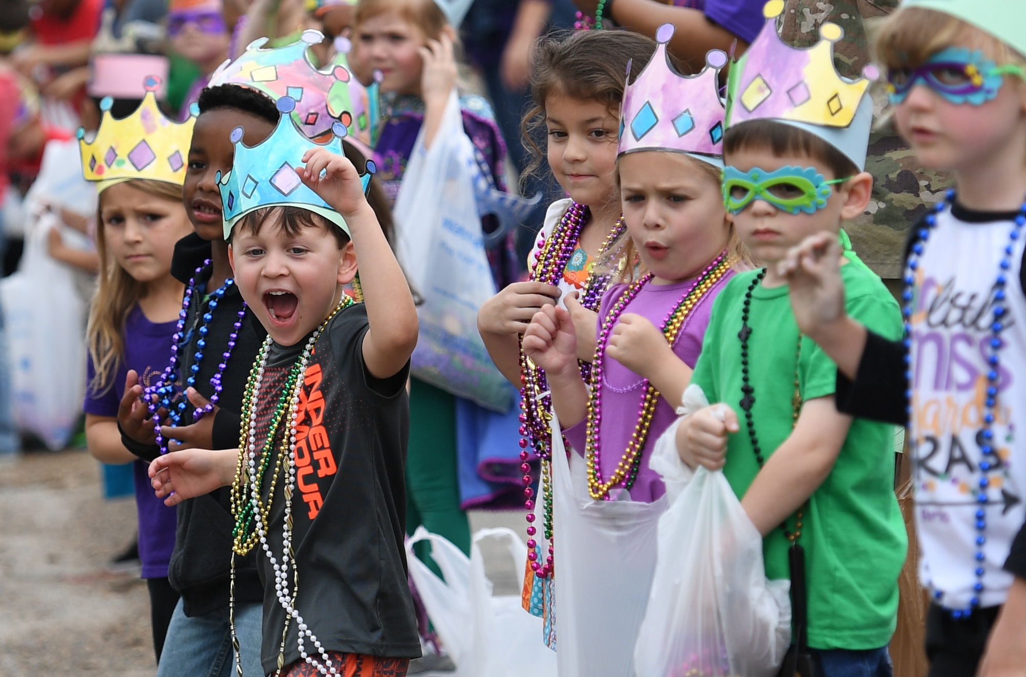 Children line the streets yelling for beads to be thrown his way while standing among class mates during the Jeff Davis Elementary School Mardi Gras parade in Biloxi, Mississippi, March 1, 2019. Keesler leadership, Honor Guard and Airmen participated in various festivities throughout the Mardi Gras season, which is celebrated by the local communities. (U.S. Air Force photo by Kemberly Groue)