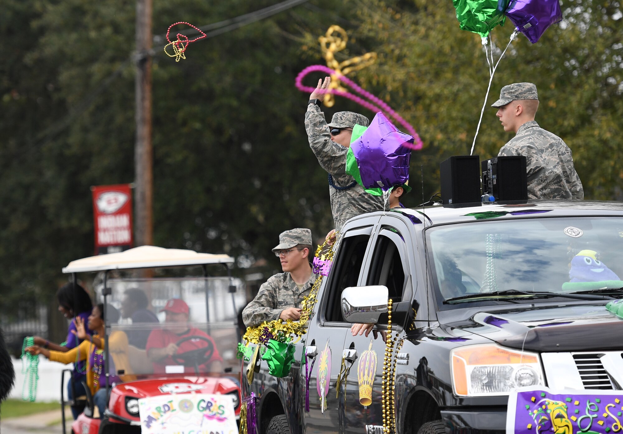 U.S. Air Force Chief Master Sgt. Andrew Bodine, 81st Training Group military training superintendent, (center), tosses beads to children as Airmen from the 81st TRG look on during the Jeff Davis Elementary School Mardi Gras parade in Biloxi, Mississippi, March 1, 2019. Keesler leadership, Honor Guard and Airmen participated in various festivities throughout the Mardi Gras season, which is celebrated by the local communities. (U.S. Air Force photo by Kemberly Groue)