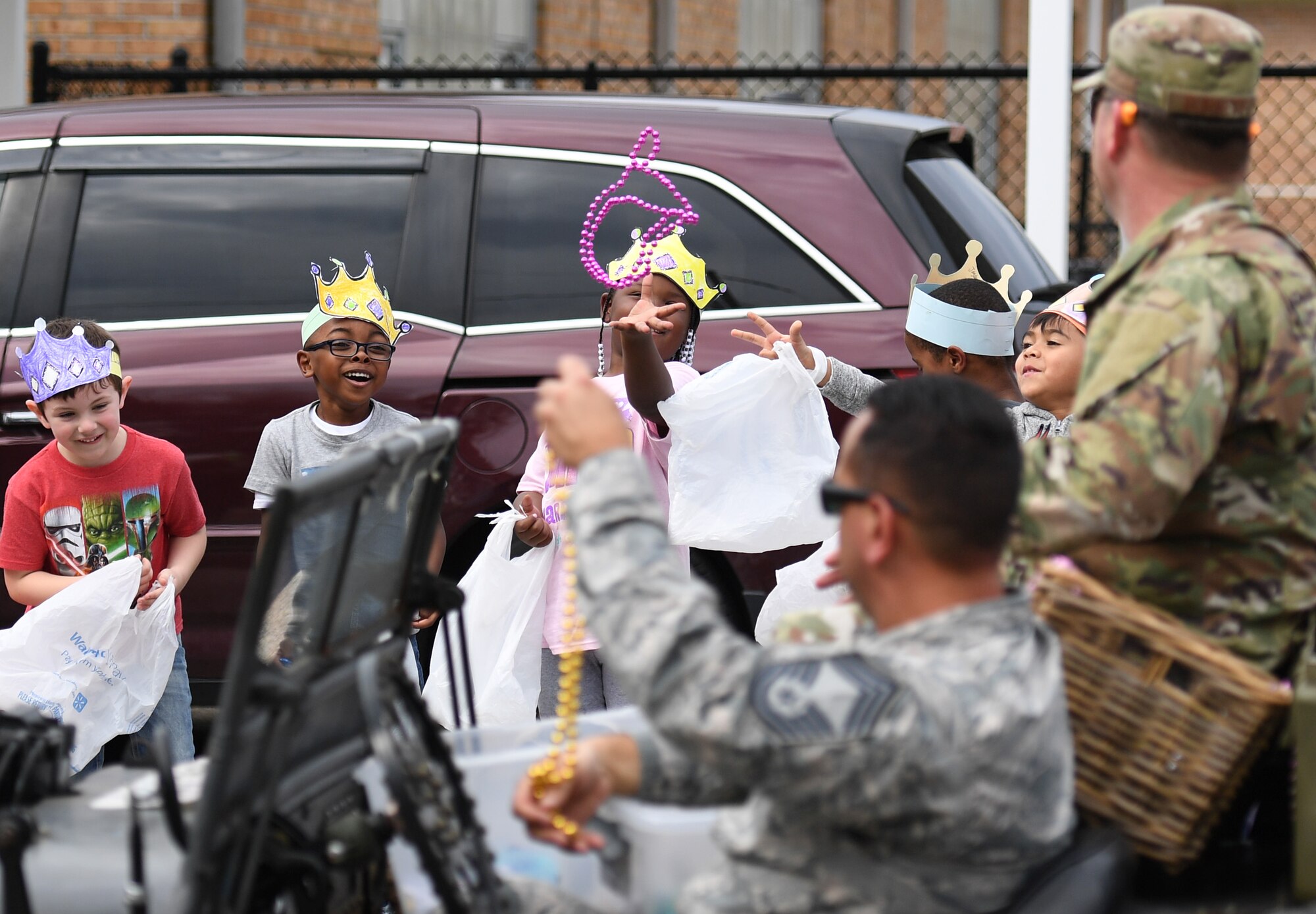 U.S. Air Force Col. Lance Burnett, 81st Training Wing vice commander, and Chief Master Sgt. Ricardo Russo, Keesler Medical Center superintendent, toss beads to children during the Jeff Davis Elementary School Mardi Gras parade in Biloxi, Mississippi, March 1, 2019. Burnett and Russo served as the Grand Marshals while other base personnel also participated in the event. Keesler leadership, Honor Guard and Airmen participated in various festivities throughout the Mardi Gras season, which is celebrated by the local communities. (U.S. Air Force photo by Kemberly Groue)