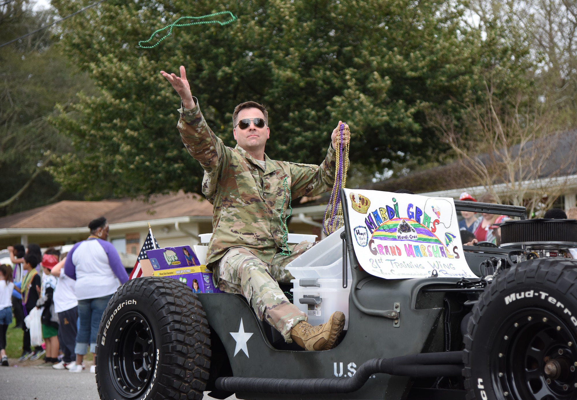 U.S. Air Force Col. Lance Burnett, 81st Training Wing vice commander, tosses beads to children during the Jeff Davis Elementary School Mardi Gras parade in Biloxi, Mississippi, March 1, 2019. Burnett and Chief Master Sgt. Ricardo Russo, Keesler Medical Center superintendent, served as the Grand Marshals while other base personnel also participated in the event. Keesler leadership, Honor Guard and Airmen participated in various festivities throughout the Mardi Gras season, which is celebrated by the local communities. (U.S. Air Force photo by Kemberly Groue)