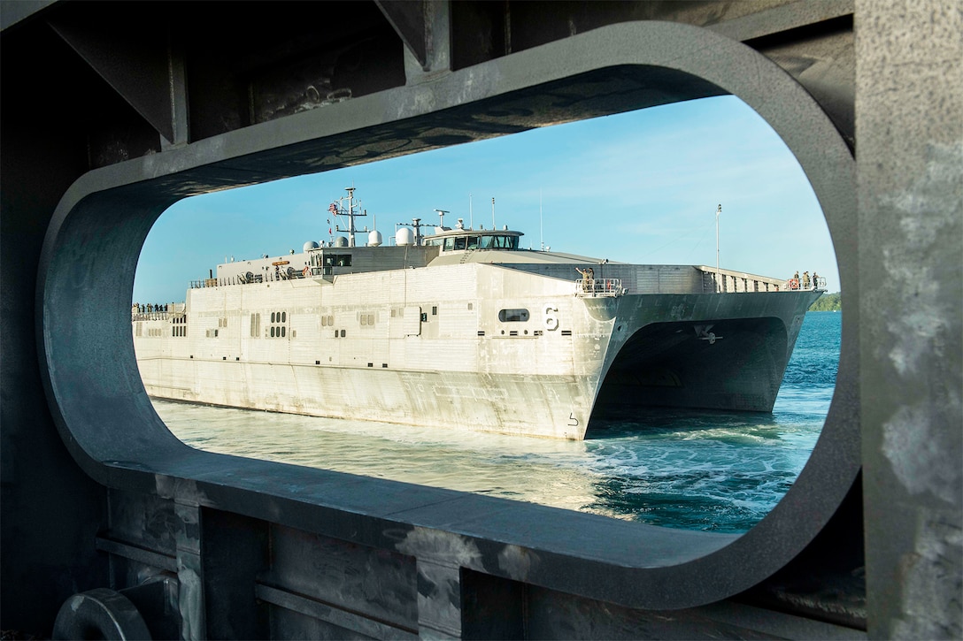 A ship departs a Naval base.