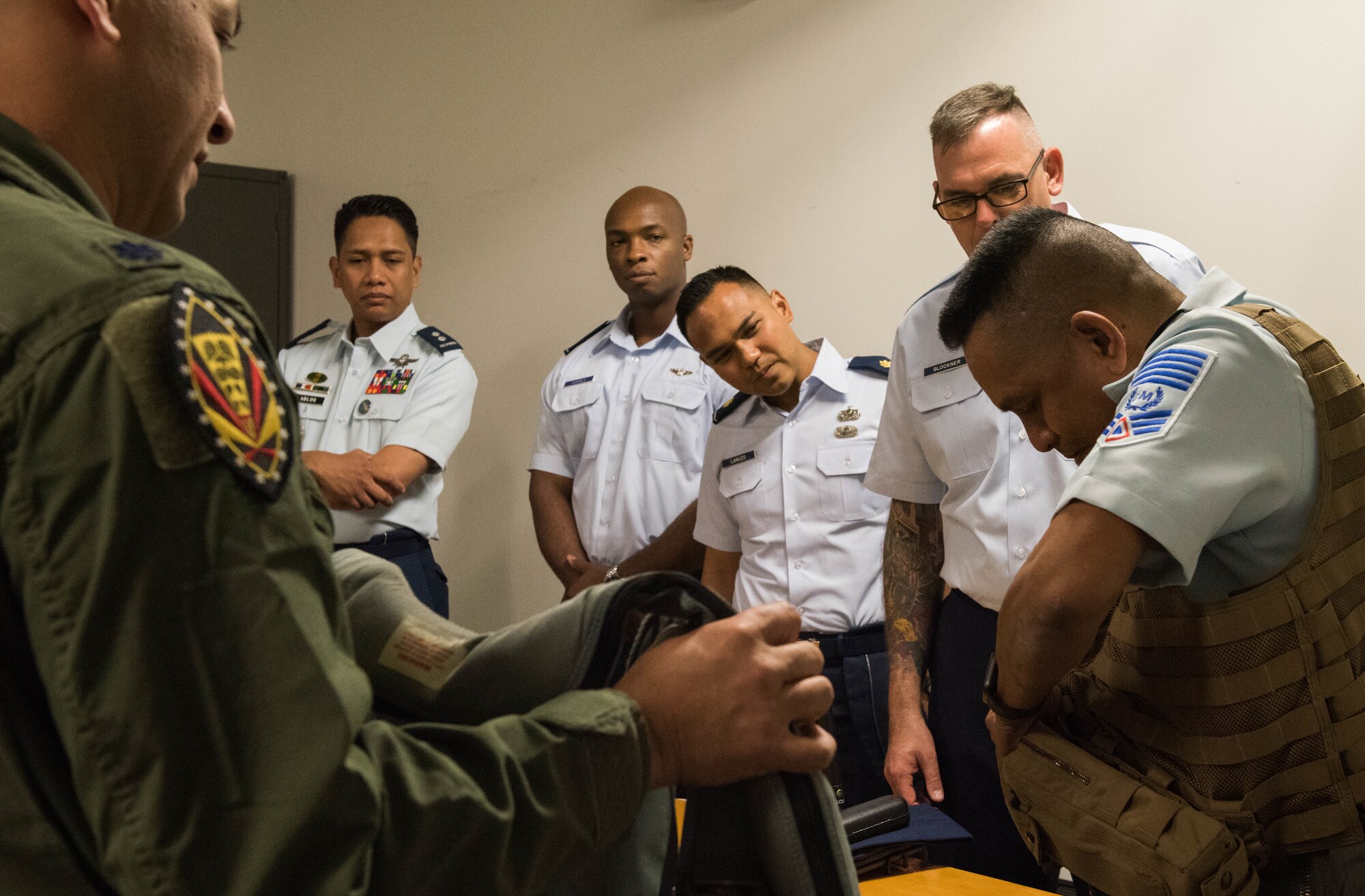 Philippine air force (PAF) Chief Master Sgt. Nelson Mercado, PAF Sergeant Major, dons pilot gear during an F-22 static display tour at Joint Base Pearl Harbor-Hickam, Hawaii, Feb. 25, 2019.