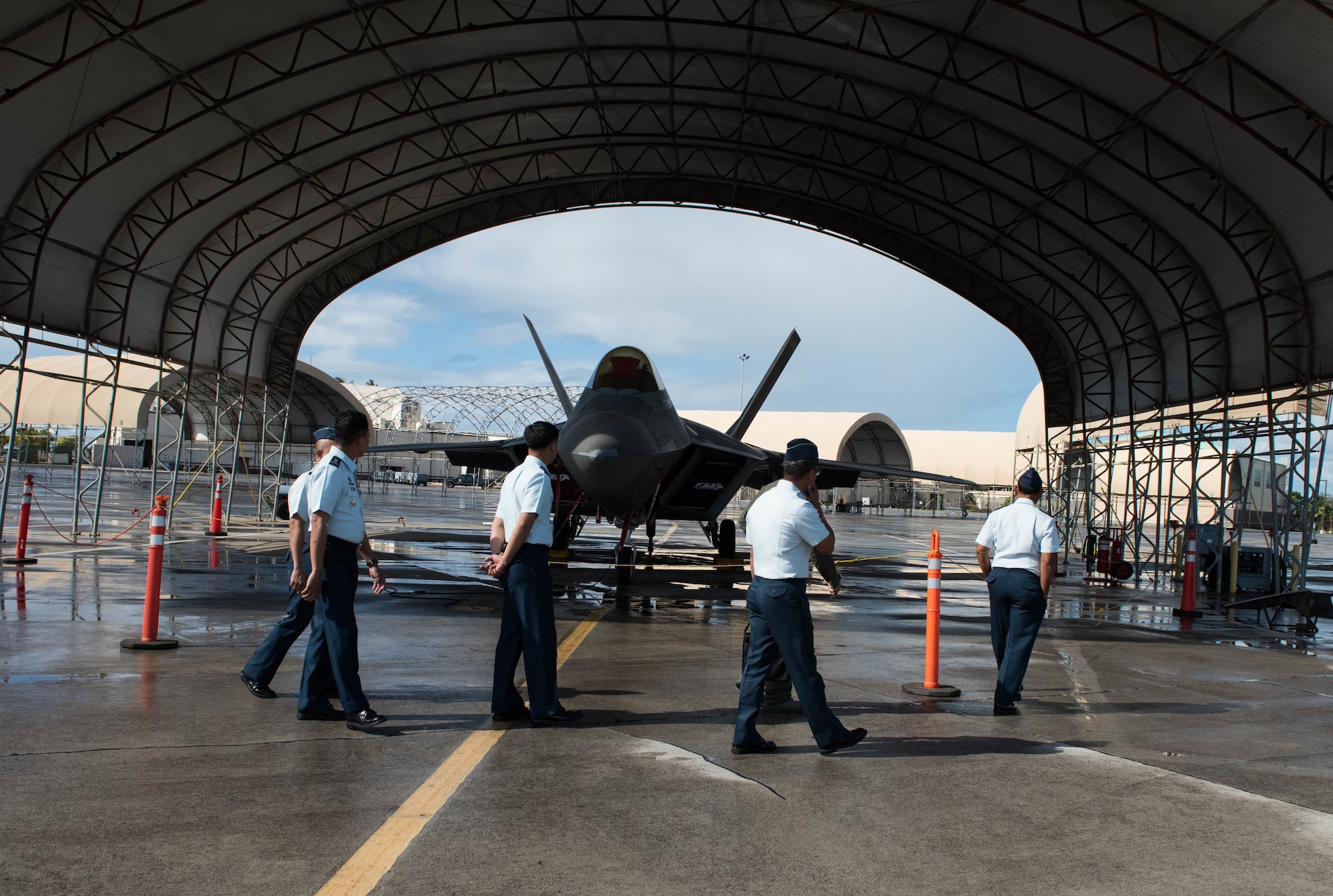 A group of U.S. and Philippine air force Airmen look at an F-22 Raptor during a tour at Joint Base Pearl Harbor-Hickam, Hawaii, Feb. 25, 2019.