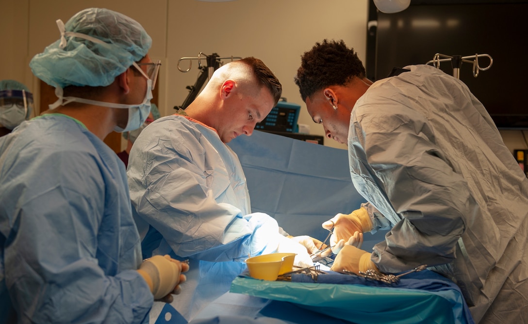 Petty Officer 1st Class Jeremiah Hays, an instructor with the Surgical Technologist program at the Medical Education and Training Campus, and San Antonio Spurs player Dejounte Murray, perform a mock surgery in a simulated operating room. Murray's visit was organized ahead of the Spurs' Navy-themed Military Salute Night.