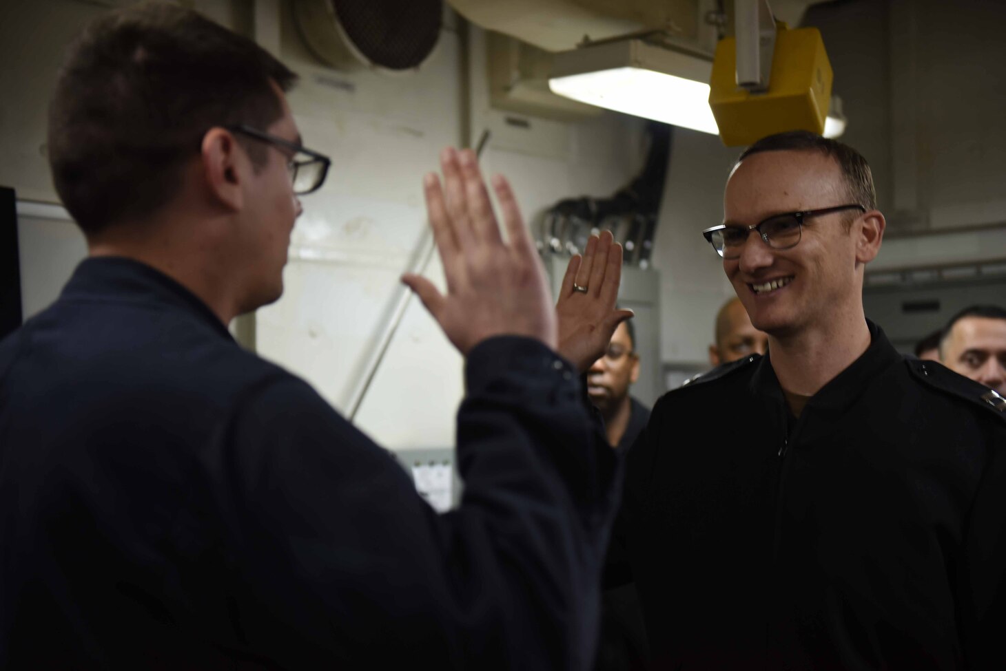 7th Fleet Communications Officer Lt. Christopher R. Jennings, administers the oath of enlistment to Information Systems Technician 2nd Class Jacob Brimhall during his reenlistment at-sea aboard USS Blue Ridge (LCC 19).