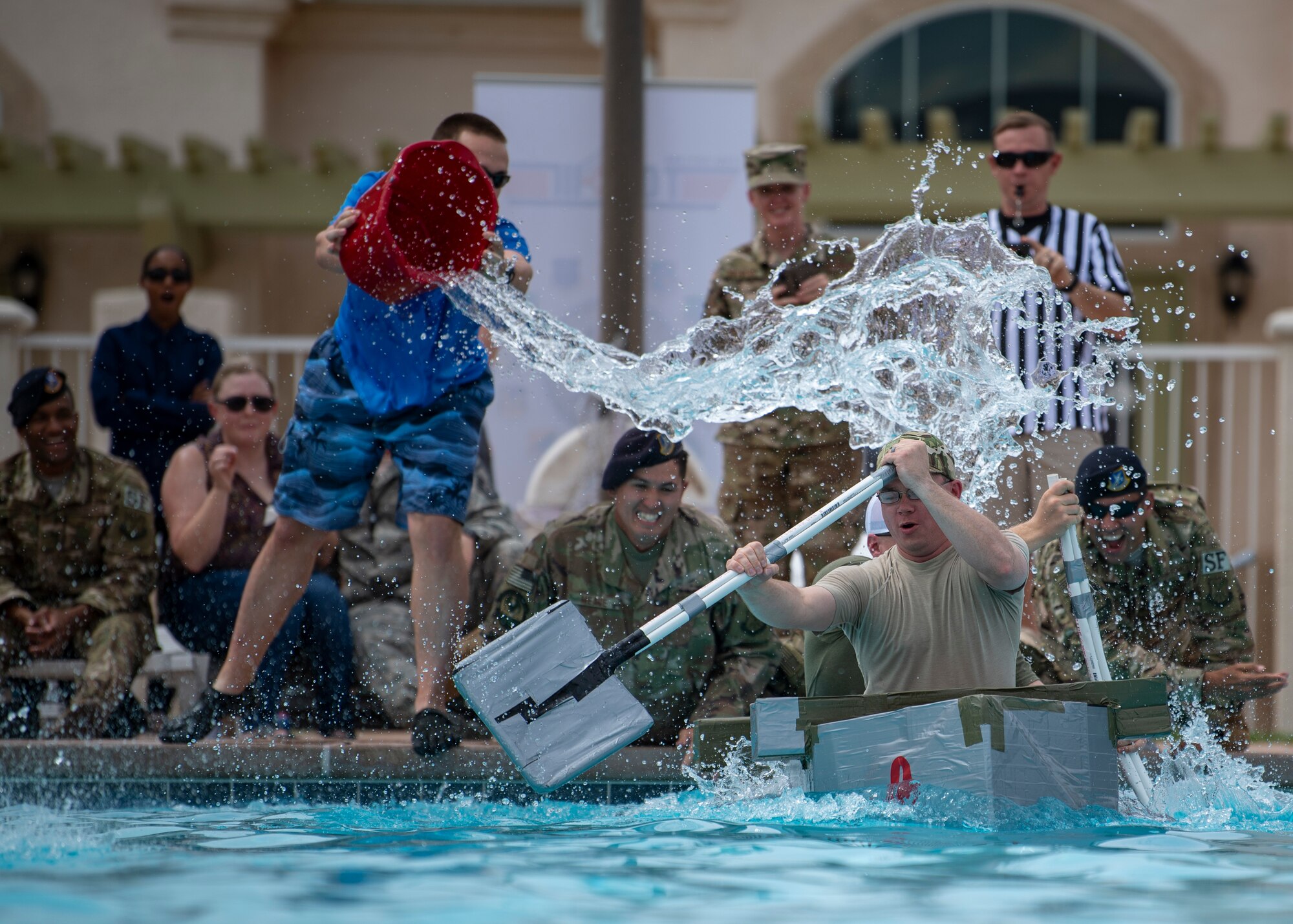 Staff Sgt. Chad Bohr and Tsgt. Tyler Dalton, 377th Weapons System Security Squadron are splashed by spectators during the Battle of the Battleships, here, Aug. 30. Bohr and Dalton's ship, “Ops Boat,” placed second overall. (U.S. Air Force photo by Staff Sgt. J.D. Strong II)