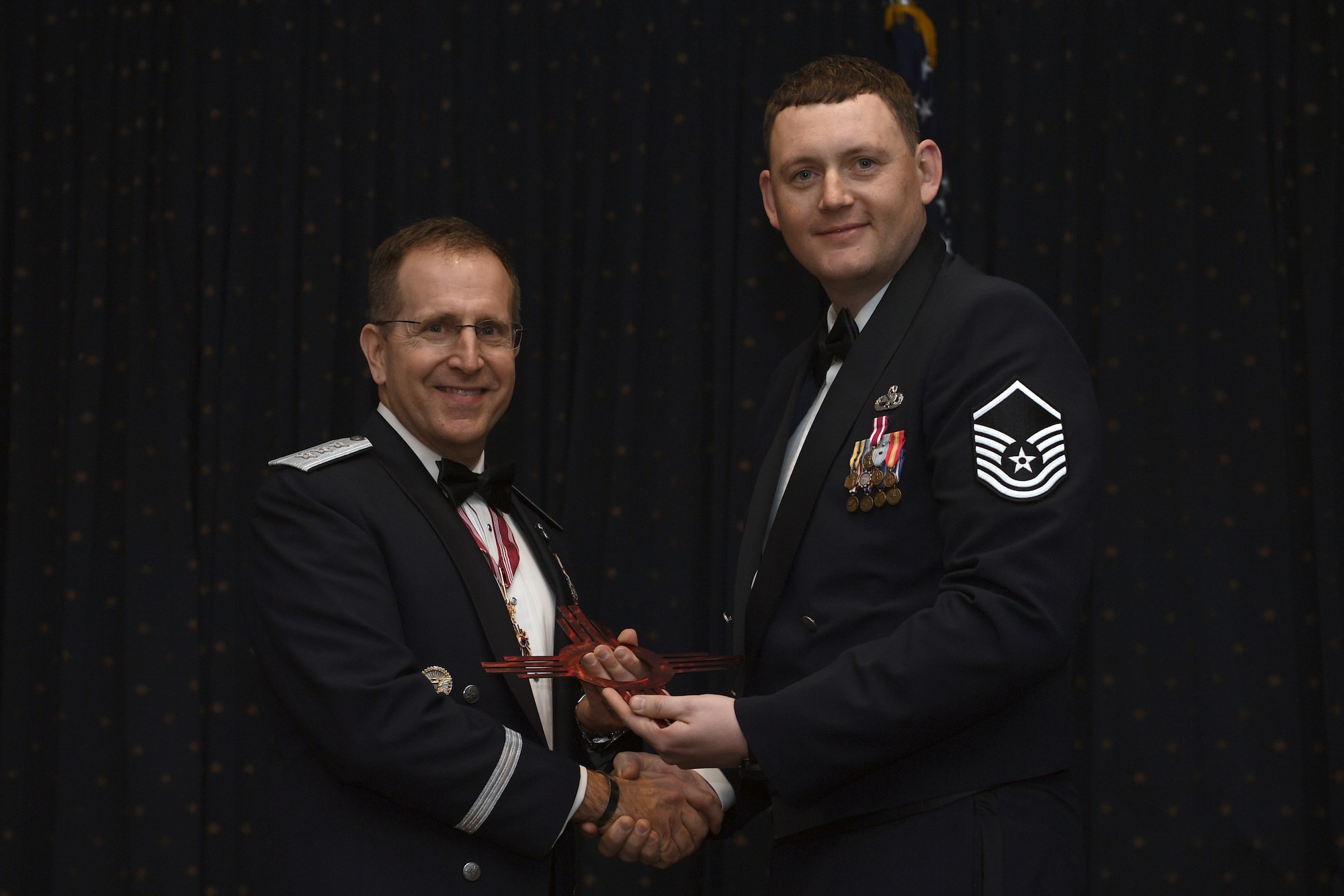 U.S. Air Force Lt. Gen. James C. Slife, United States Special Operations Command vice commander, left, is presented a gift from U.S. Air Force Master Sgt. Donald Hettinger, 58th Maintenance Group Quality Assurance chief inspector, during the 58th Special Operations Wing Annual Awards Ceremony at Kirtland Air Force Base, N.M., Feb. 21, 2019.  Slife toured the 58th SOW during the day before speaking during the awards ceremony as the guest speaker. The ceremony highlighted members for their outstanding work throughout the year.  (U.S. Air Force photo by Staff Sgt. Dylan Nuckolls)