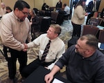 Felix Saenz, AFIMSC budget analyst for Air Force Materiel Command (left), meets Keith Tarnovich, Mission Support Group team chief, Wright-Patterson Air Force Base, Ohio, and Keith Westerbeck, Financial Management Analysis Office chief, Tinker Air Force Base, Oklahoma, during the AFIMSC Budget Officers Summit in San Antonio Feb. 28.