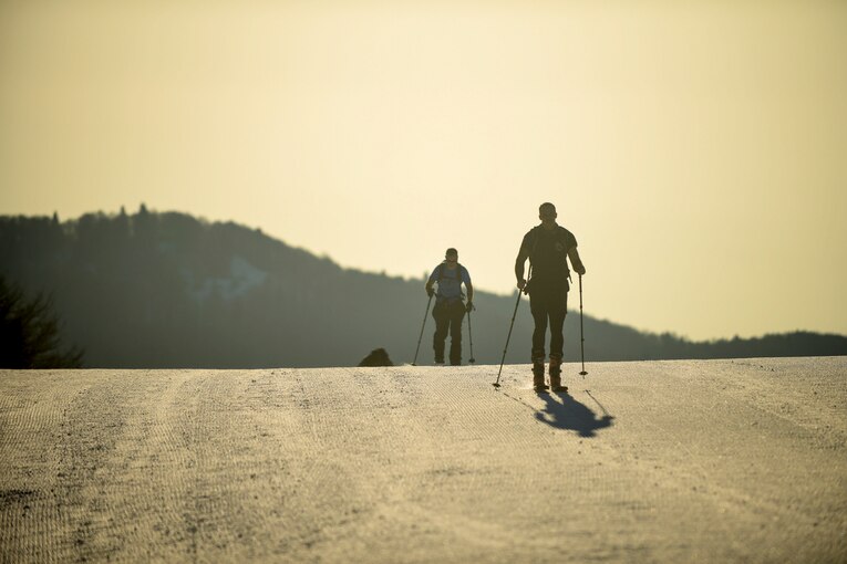 Airmen ascend a slope on skis.