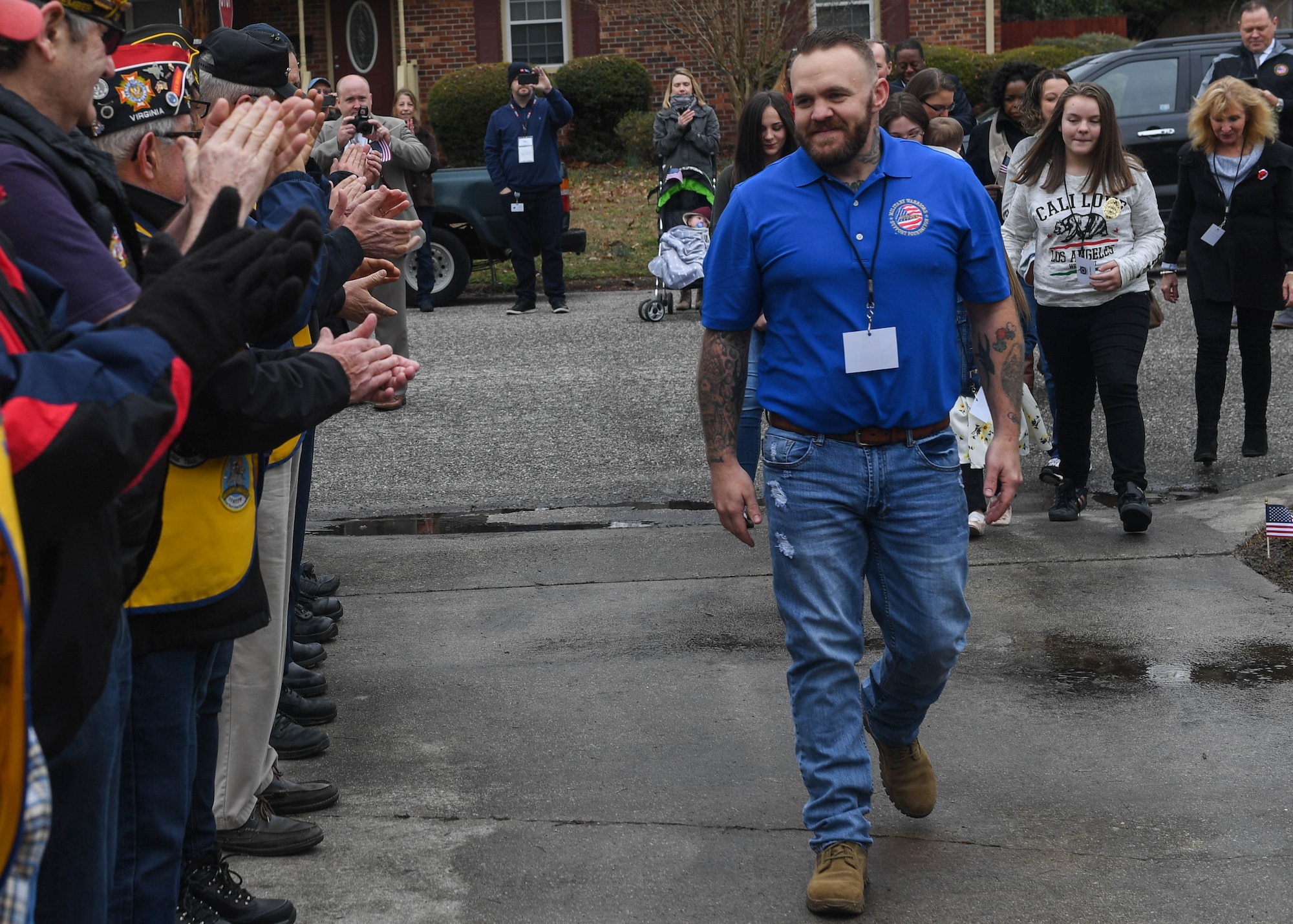 Joshua Howe, a retired U.S. Army Staff Sgt., leads his family up the driveway to their new home in Newport News, Virginia, March 2, 2019. Howe was selected by SunTrust Bank and Military Warriors Support Foundation to receive a mortgage free home to help him and his family live a better post-service life. (U.S. Air Force photo by Senior Airman Derek Seifert)