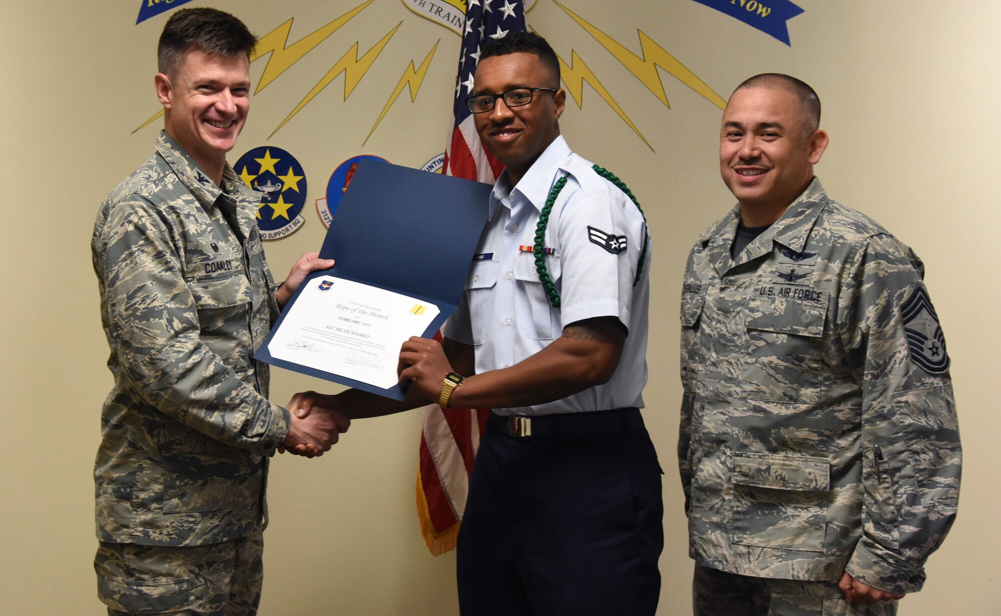 U.S. Air Force Col. Thomas Coakley, 17th Training Group commander, presents the 312th Training Squadron Student of the Month award to Airman 1st Class Mude Hamid, 312th TRS student, at the Brandenburg Hall on Goodfellow Air Force Base, Texas, March 1, 2019. The 312th TRS’s mission is to provide Department of Defense and international customers with mission ready fire protection and special instruments graduates and provide mission support for the Air Force Technical Applications Center. (U.S. Air Force photo by Airman 1st Class Abbey Rieves/Released)